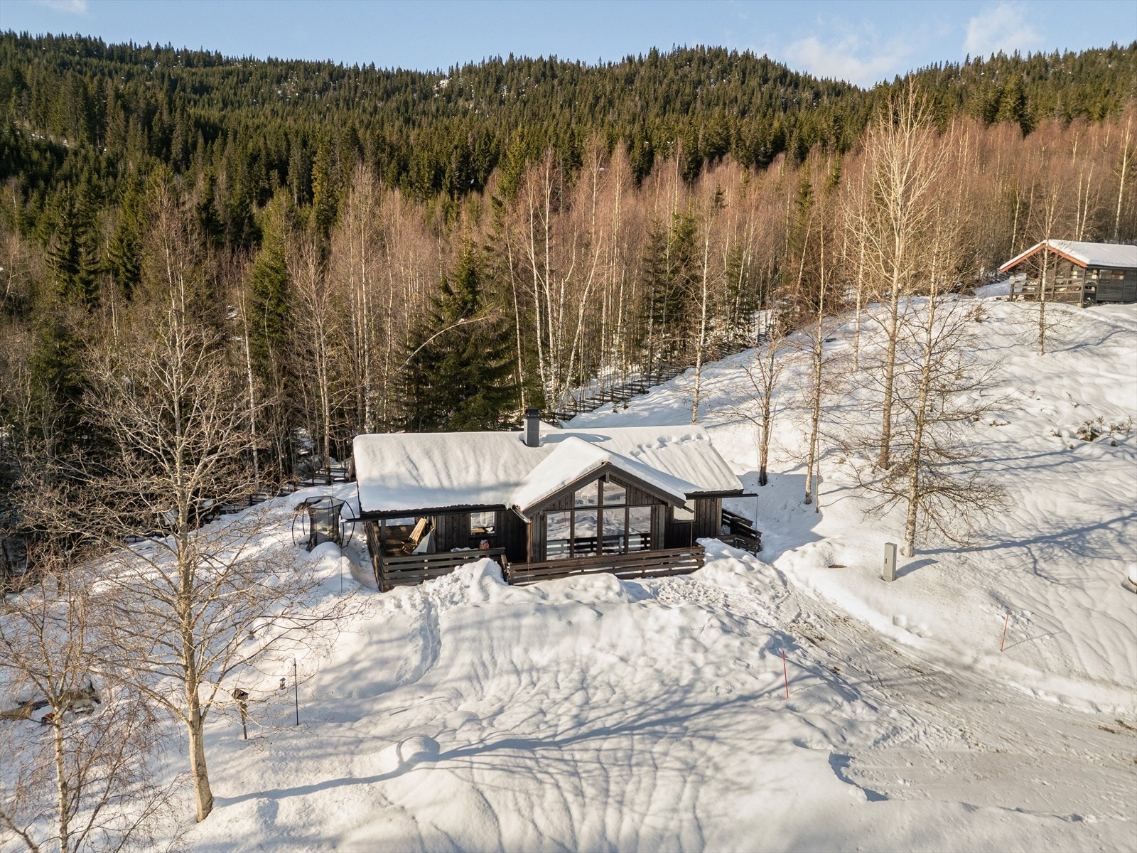 Det karakteristiske utstikket fra stuedelen gir hytta et moderne og spennende uttrykk, samtidig som det skaper ekstra takhøyde og en imponerende, luftig romfølelse inne. Galleribilde