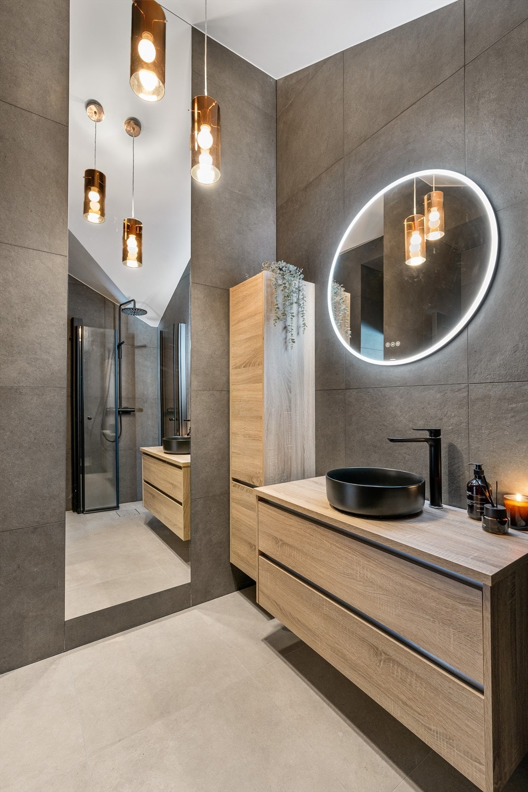 Sorte håndkletørkere på veggen tilfører både praktisk komfort og et sofistikert preg, mens detaljer som herdet glass med sorte profiler og downlights i himlingen fullfører det moderne og luksuriøse uttrykket. Galleribilde