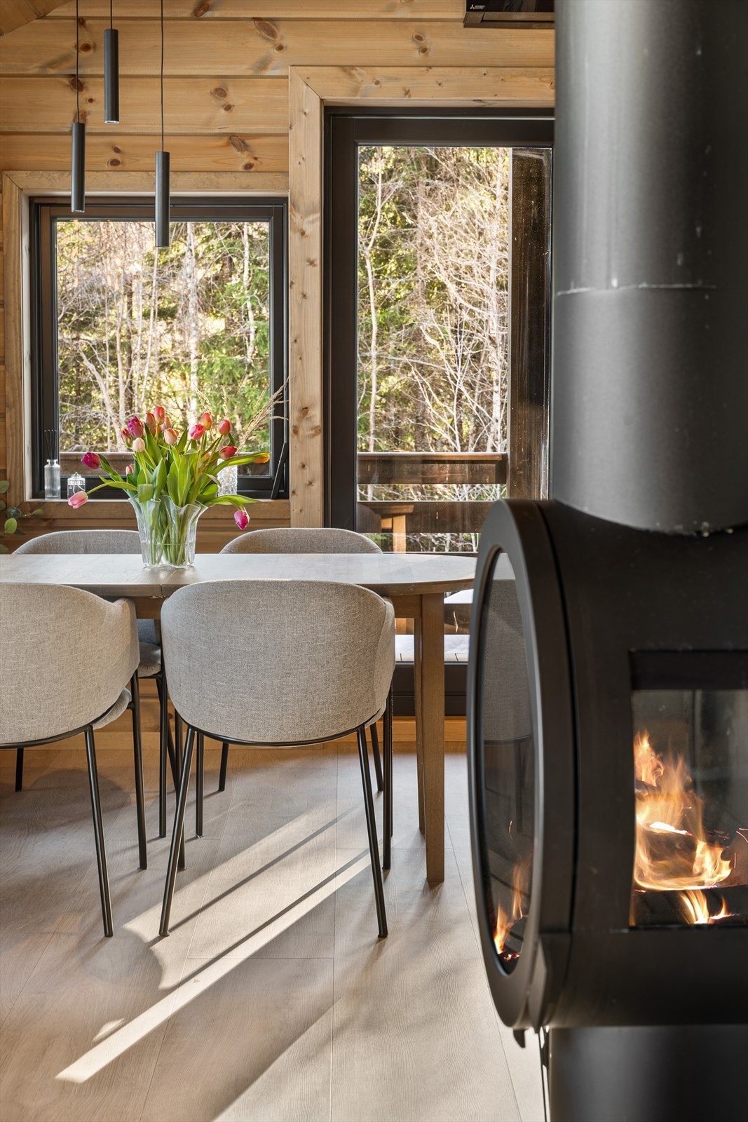 Den moderne, runde peisovnen blir et naturlig midtpunkt i rommet - flammene skaper en lun og stemningsfull atmosfære som virkelig forsterker følelsen av ekte hytteliv. Galleribilde
