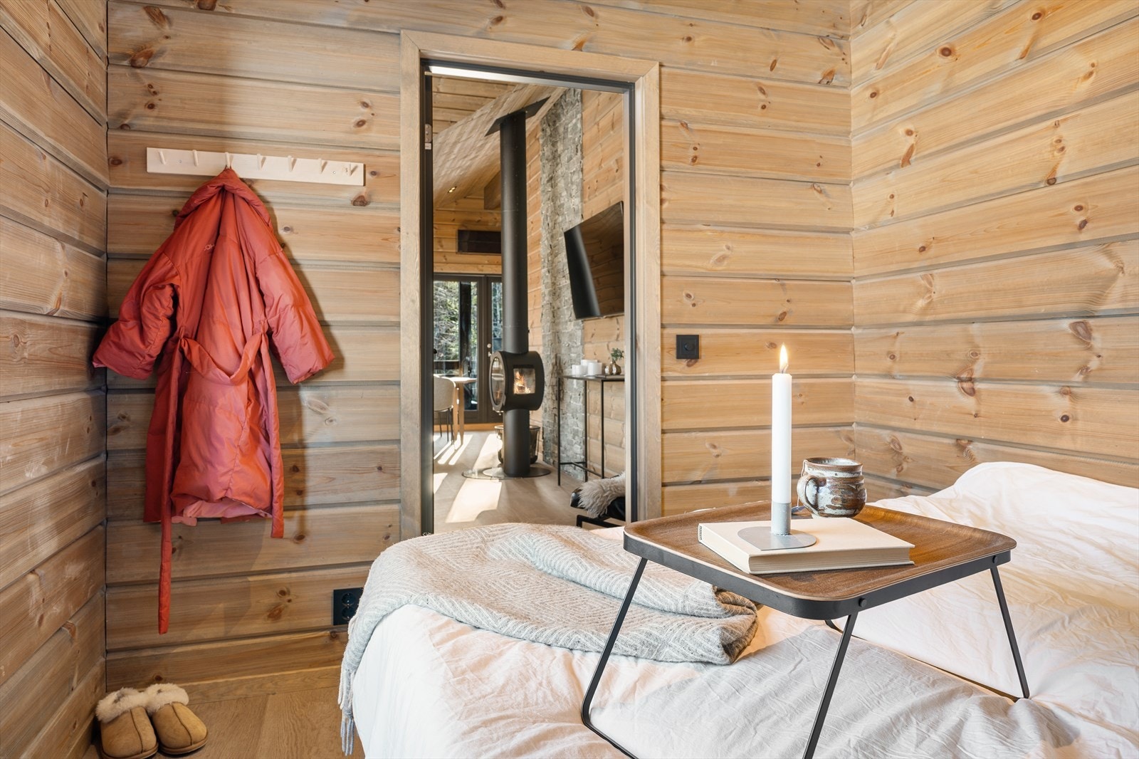 Hovedsoverommet er innbydende og lunt, innredet med en utrekkseng som enkelt kan gjøres om til dobbeltseng - perfekt for en avslappende natt på hytta. Fra rommet er det enkel adkomst til stuen, som gjør det lett å kombinere privatliv og sosialt samvær. Galleribilde