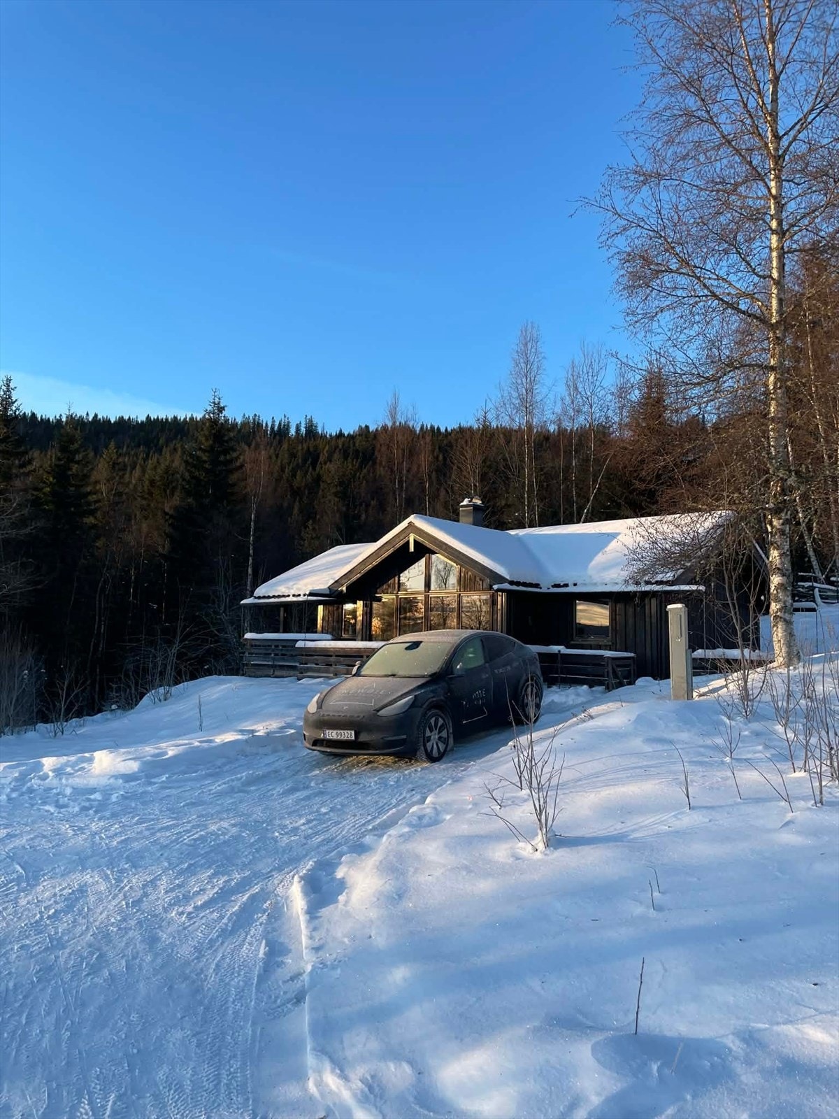 Selgers private bilde: Det er montert ladeboks for El-bil på yttervegg i kort avstand til biloppstillingsplassen foran hytta. Galleribilde