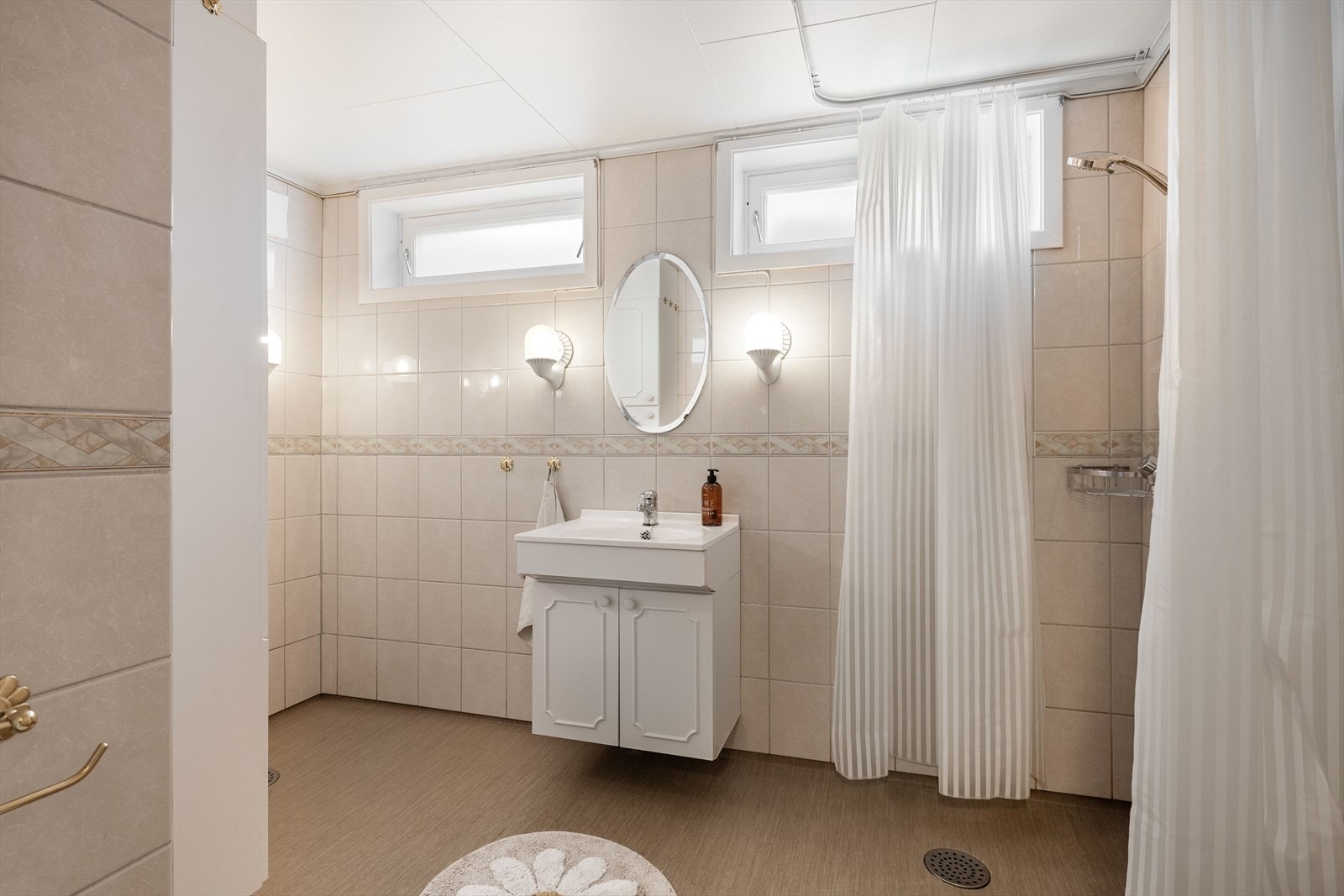 Bad i underetasjen med enkel servant og innredning, dusjhjørne med forheng og opplegg for vaskemasking. Galleribilde