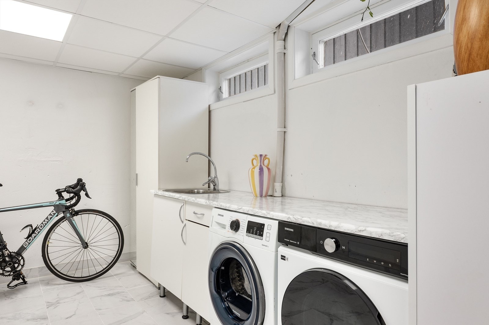 Noe oppgradert vaskerom med en plassrik innredning. Opplegg for vaskemaskin og tørketrommel. Galleribilde