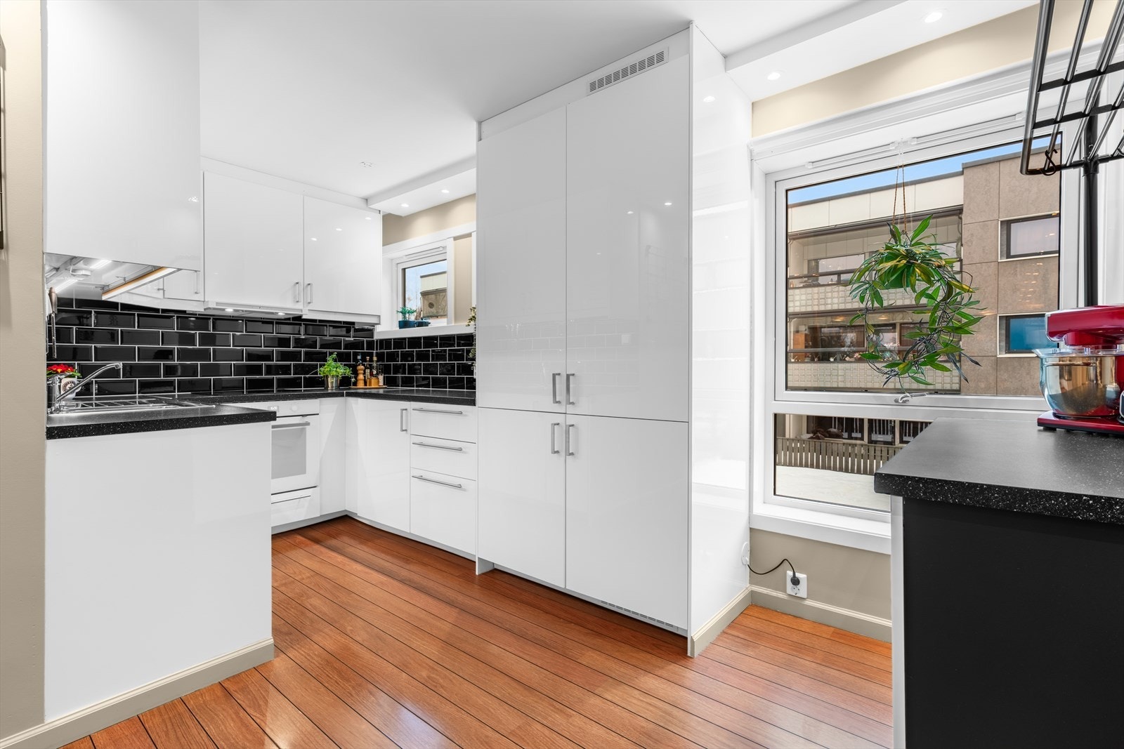 Kjøkkeninnredning fra 2018 under-/overskap og slette fronter. Benkeplater av laminat med nedfelt kum i rustfritt stål og ett-greps blandebatteri. Integrerte hvitevarer som komfyr, platetopp, oppvaskmaskin og kjøl/frys. Galleribilde