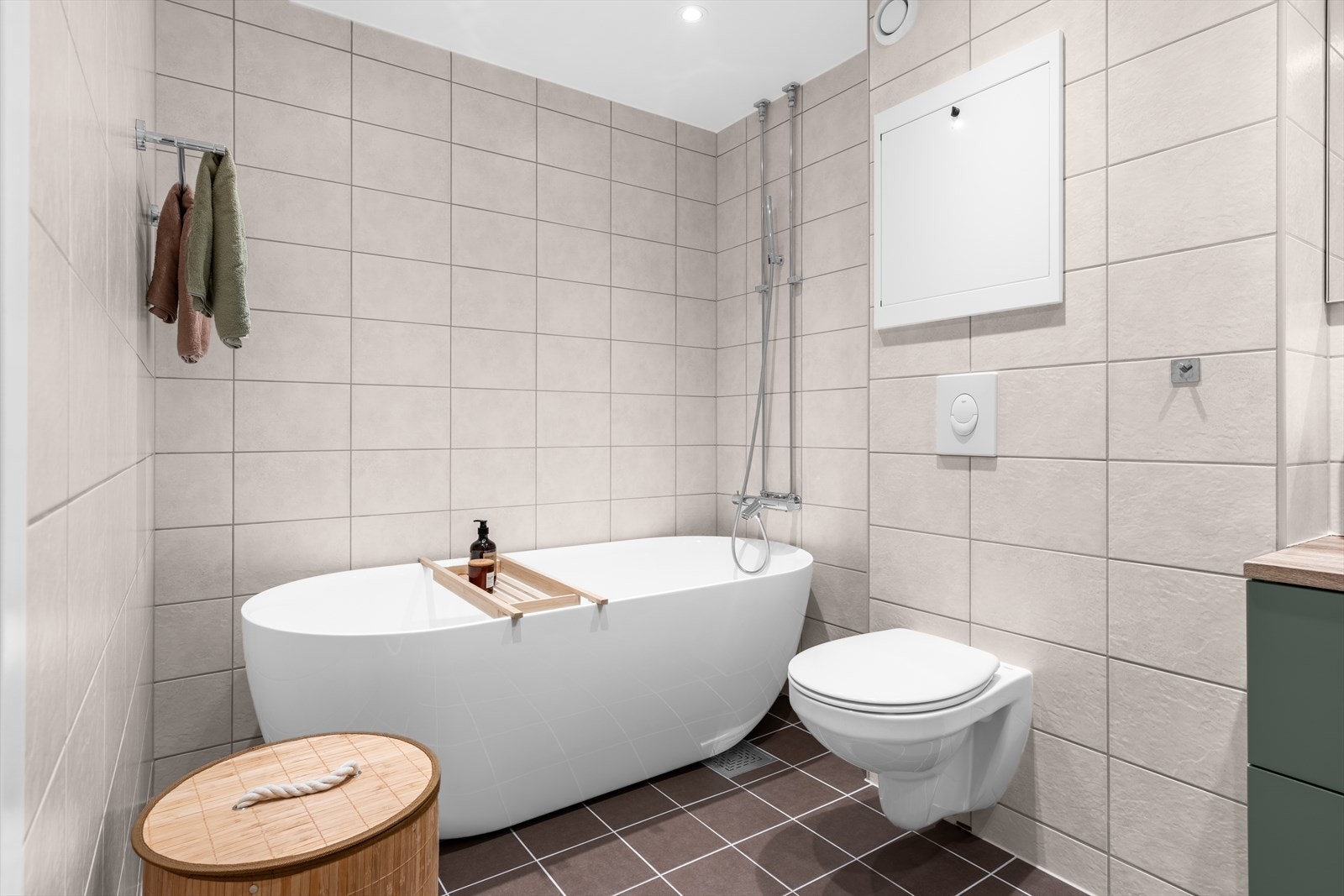 Hovedbadet finner vi i boligens andre plan. Badet er innredet med servantskap, 2 stk porselensservanter, 2 stk med ett-greps blandebatterier, høyskap, veggspeil, vegghengt toalett
med innebygget sisterne, badekar, blandebatteri og dusjgarnityr. Galleribilde