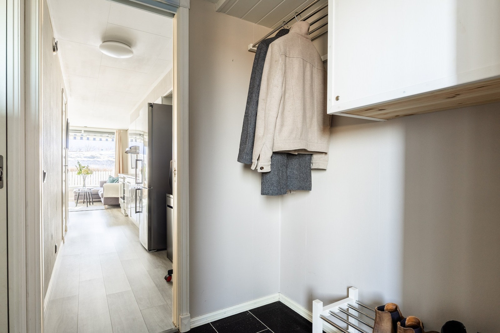 Lys, romslig entré med plass til oppheng av yttertøy og oppbevaring av yttertøy. Galleribilde