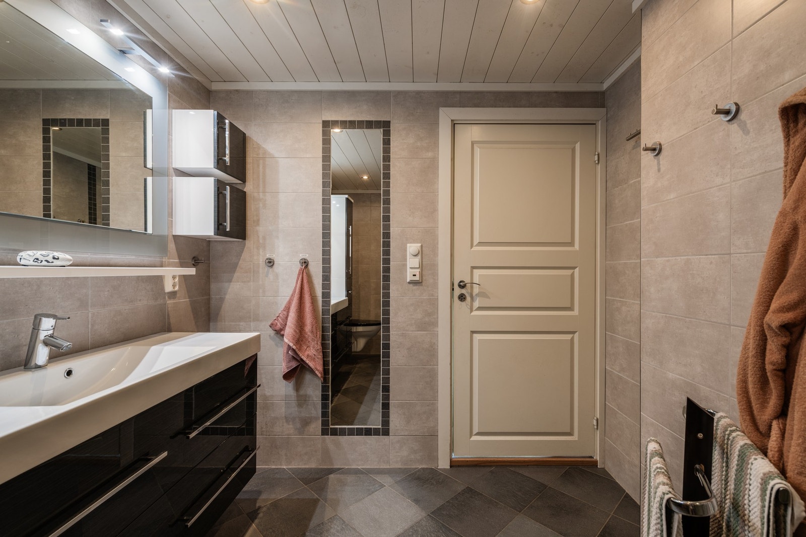 Servantinnredning, vegghengt toalett og dusj med vegger i glass. Galleribilde