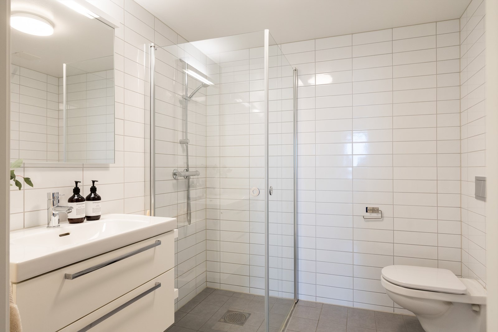 Baderommet har himlinger med malte plater, og er innredet med vegghengt klosett, baderomsinnredning med heldekkende servant, speil og dusjvegger. Galleribilde