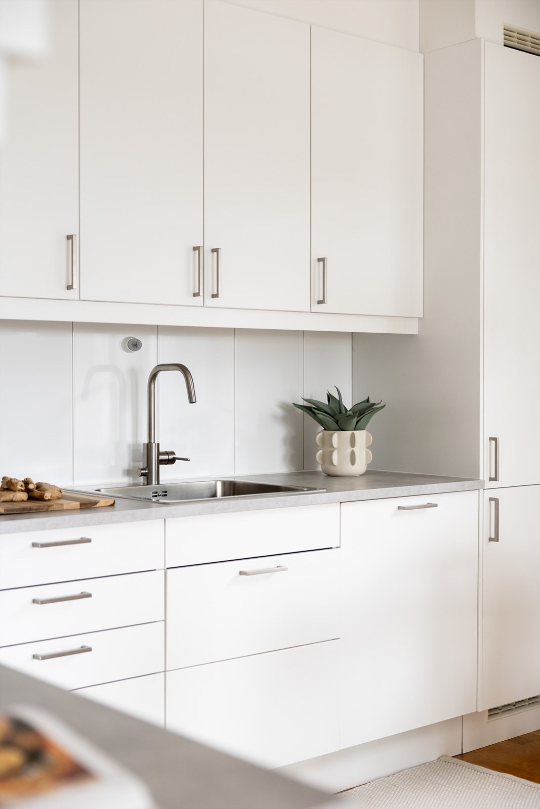 Kjøkkenet er innredet med glatte fronter og laminat benkeplate med nedfelt oppvaskkum. Galleribilde