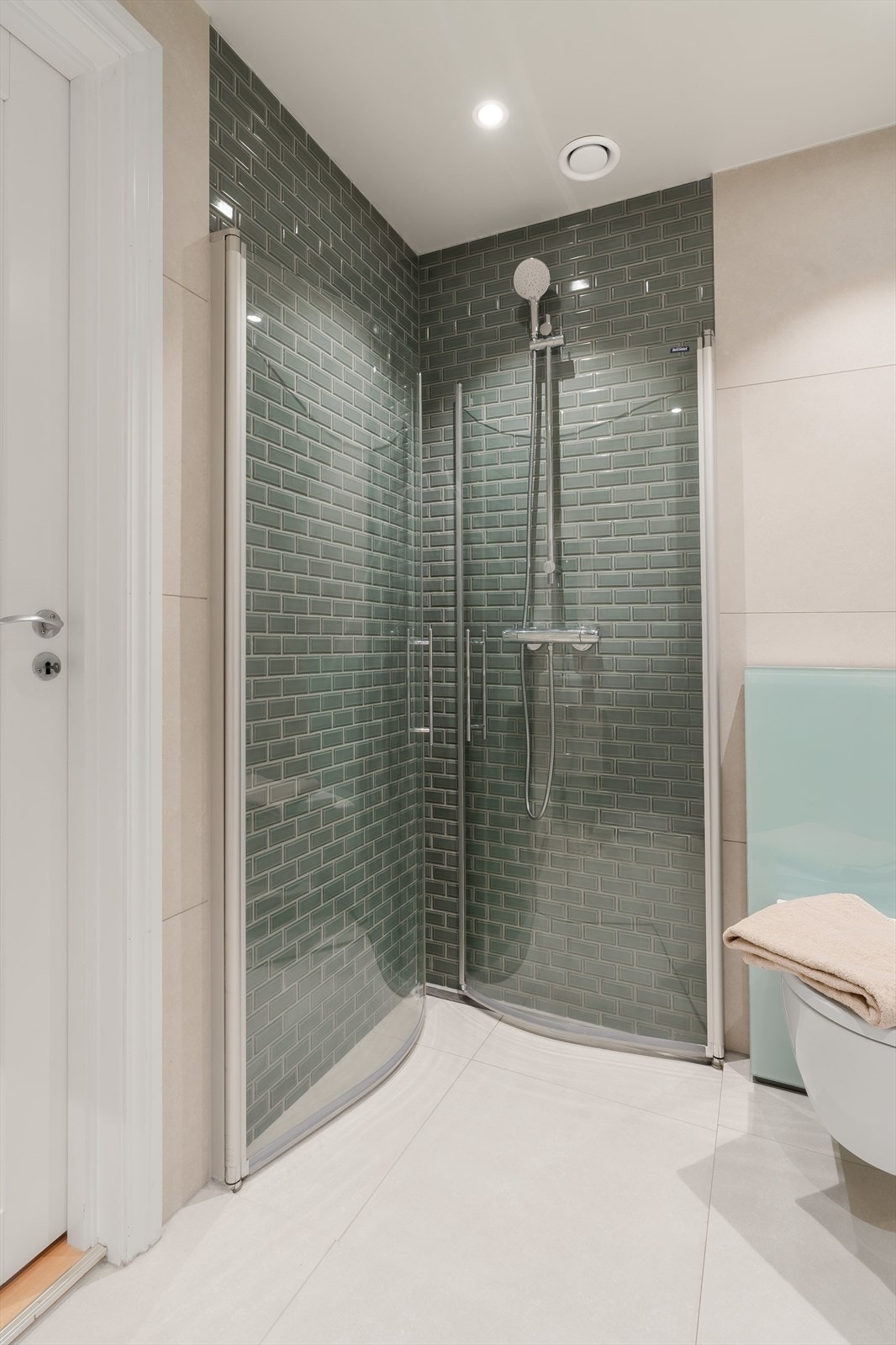 Baderommet har stilfulle grønne fliser i dusjsonen. Galleribilde