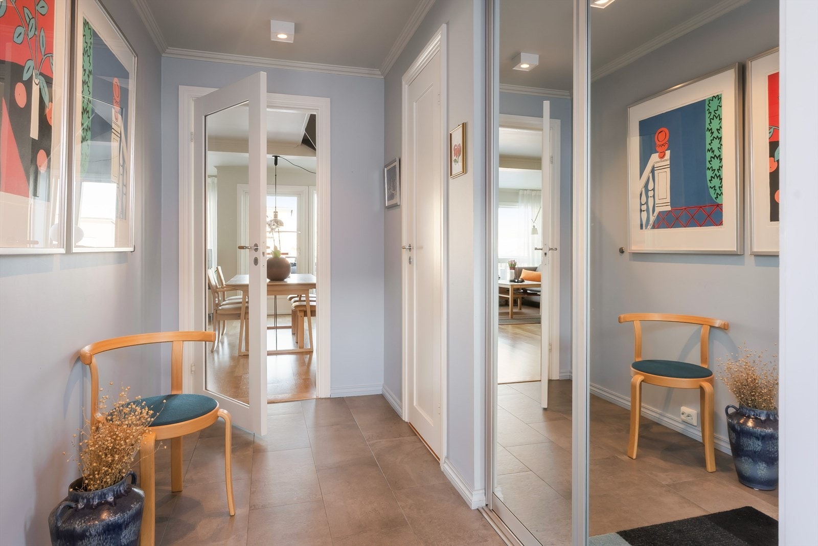 Entréen er romslig og er innredet med fliser på gulv, med gulvvarme. Vegger er malt i en behagelig farge, som gir et godt førsteinntrykk. Entréen er videre utstyrt med en praktisk skyvedørsgarderobe, med speilfronter og velplasserte downlights. Galleribilde