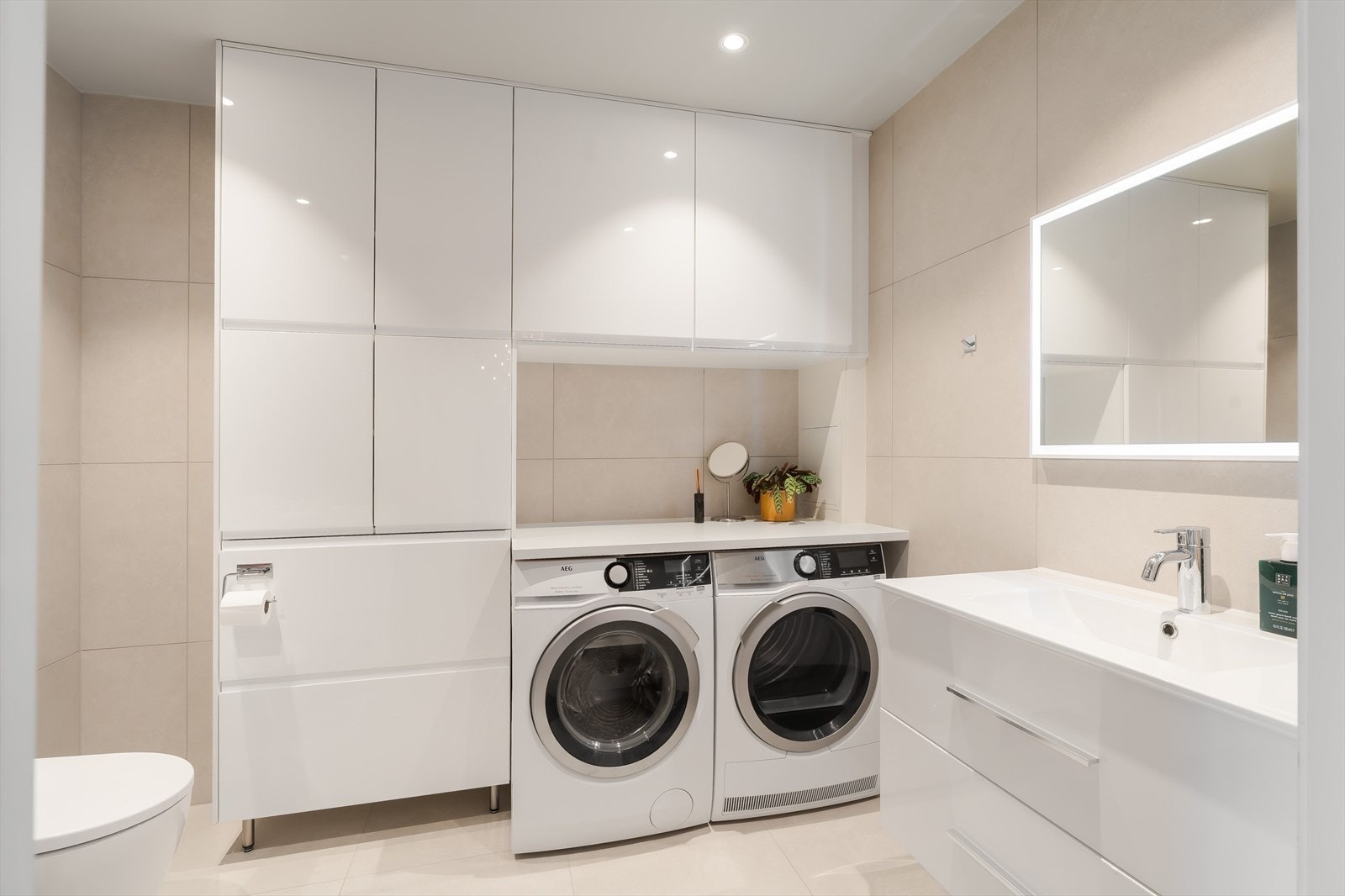 Badet har en pen og svært praktisk innredning med skuffer og skap som gir rikelig med plass for lagring. Vaskemaskin og tørketrommel medfølger i handelen. Galleribilde