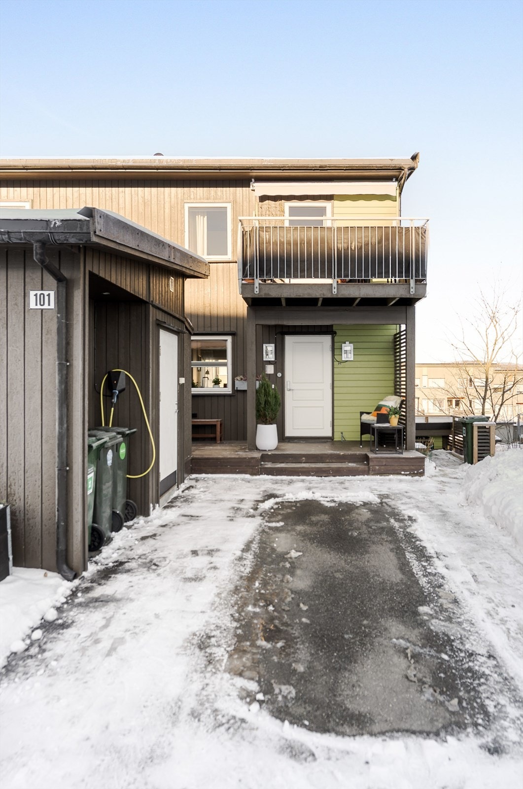 Velholdt gårdsplass som er pent asfaltert. Videre er det en praktisk bod til venstre og el-billader. Ved inngangsdøren er det også en solfylt terrasse, hvor morgensolen kan nytes. Galleribilde