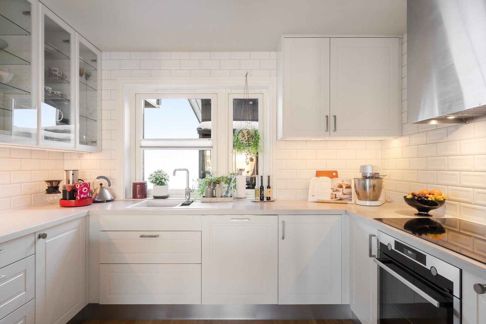 Glasskapet setter et moderne preg på kjøkkenet og det er ledlister under skapene. Galleribilde