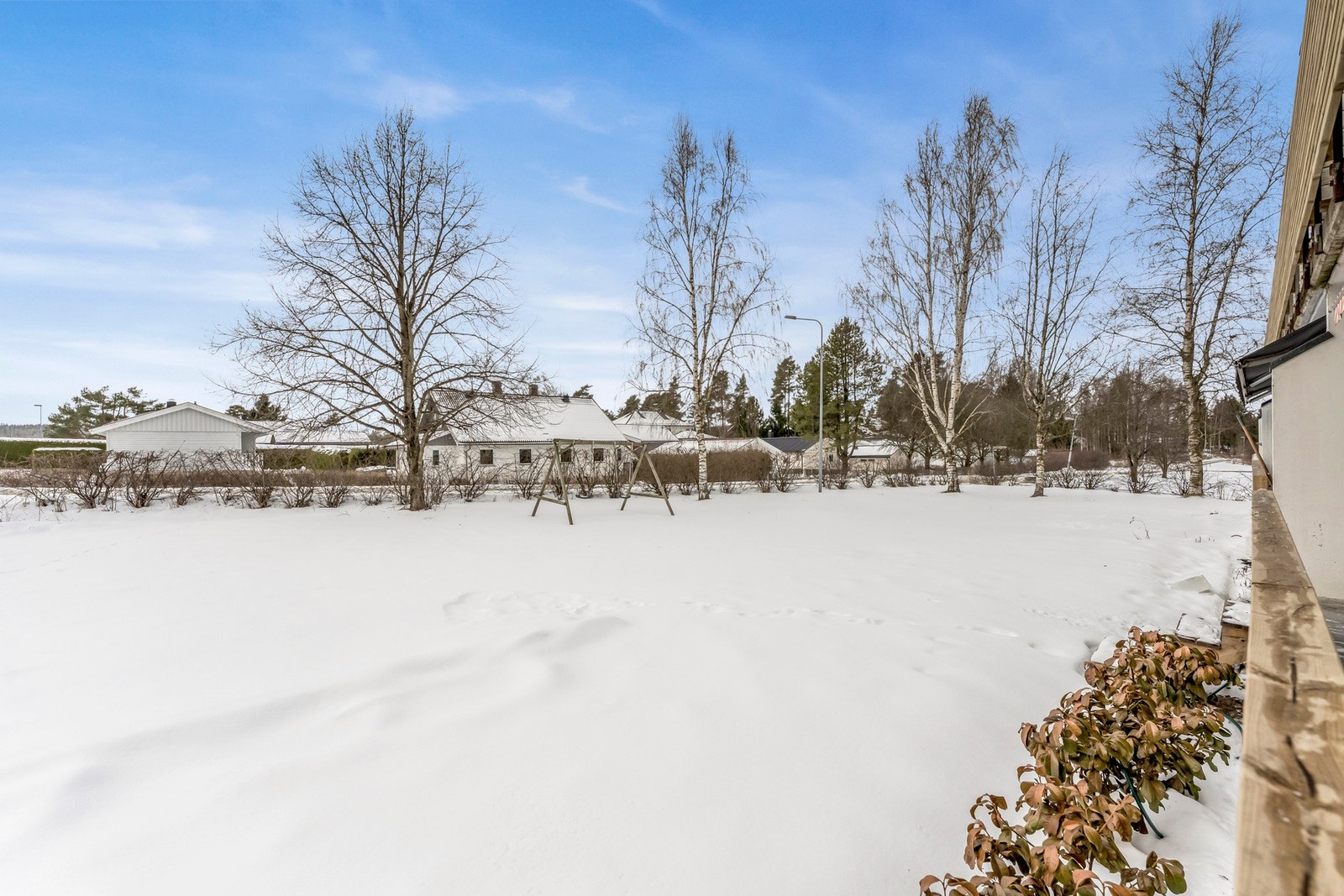 Romslig og barnevennlig fellesareal utenfor boligen. Det er trapp ned fra terrassen til hagen. Galleribilde