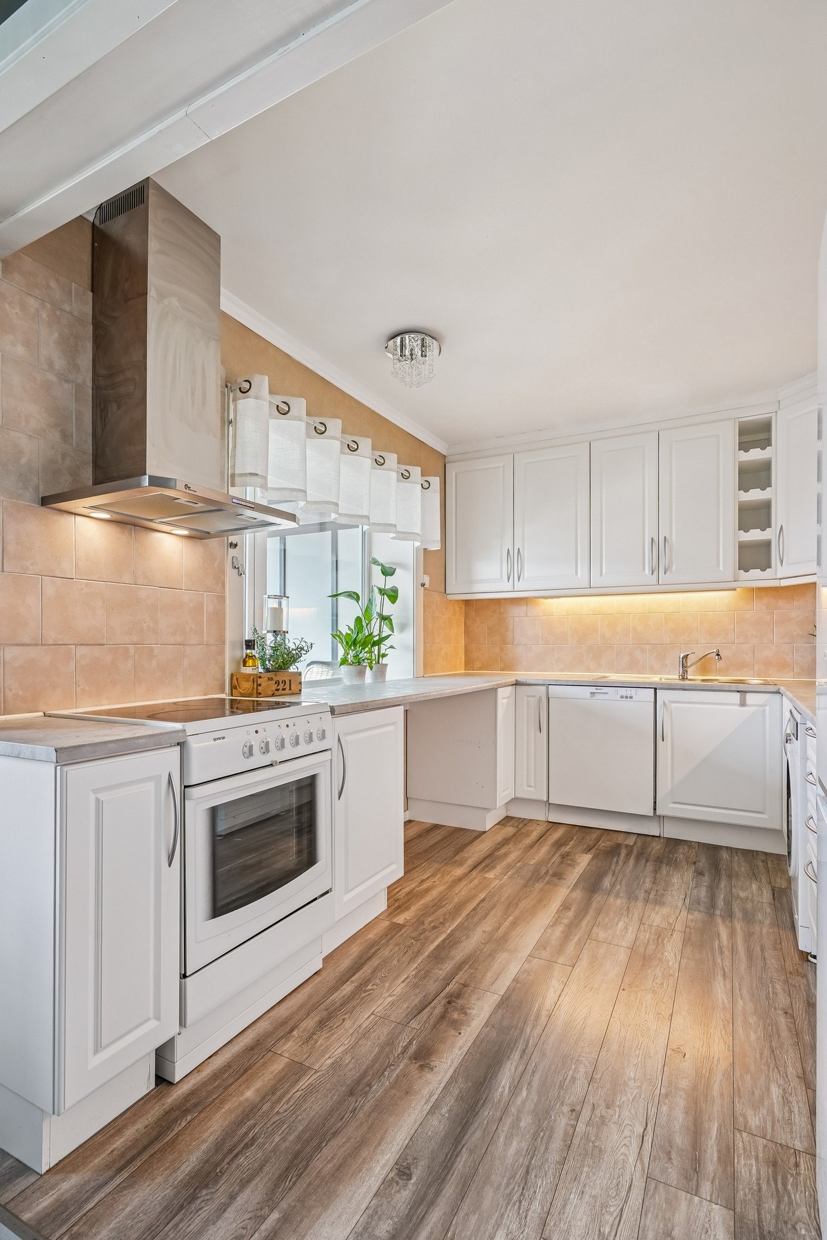 Vindu mot vest på kjøkkenet slipper inn god med naturlig lys. Plass til barstoler under benk ved vindu. Galleribilde