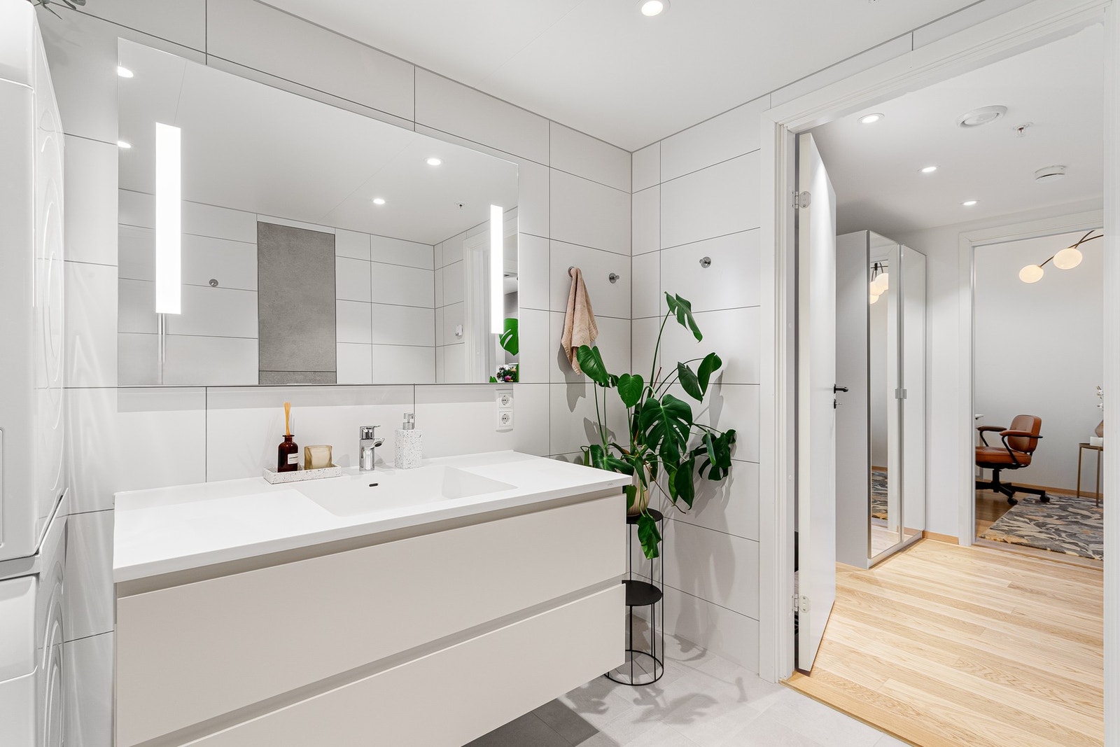 Leilighetens bad er bl.a. utstyrt med innfellbare dusjdører i glass, speil med innfelte lys og grepsfri servantinnredning. Galleribilde