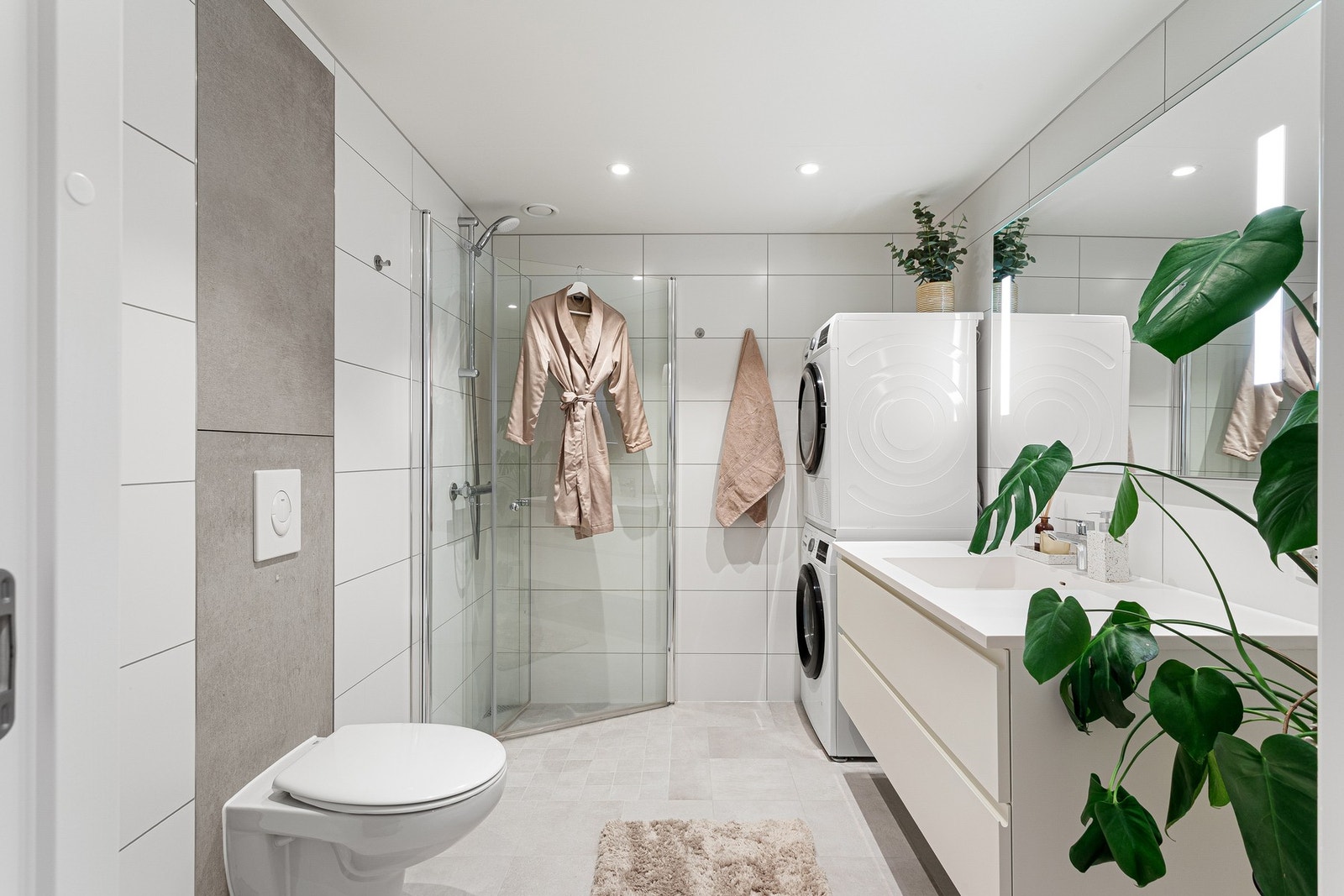 Til høyre for entréen finner du leilighetens moderne og lekre bad med flislagte overflater og spotter i himling. Måler gode 5,5 kvm. Galleribilde