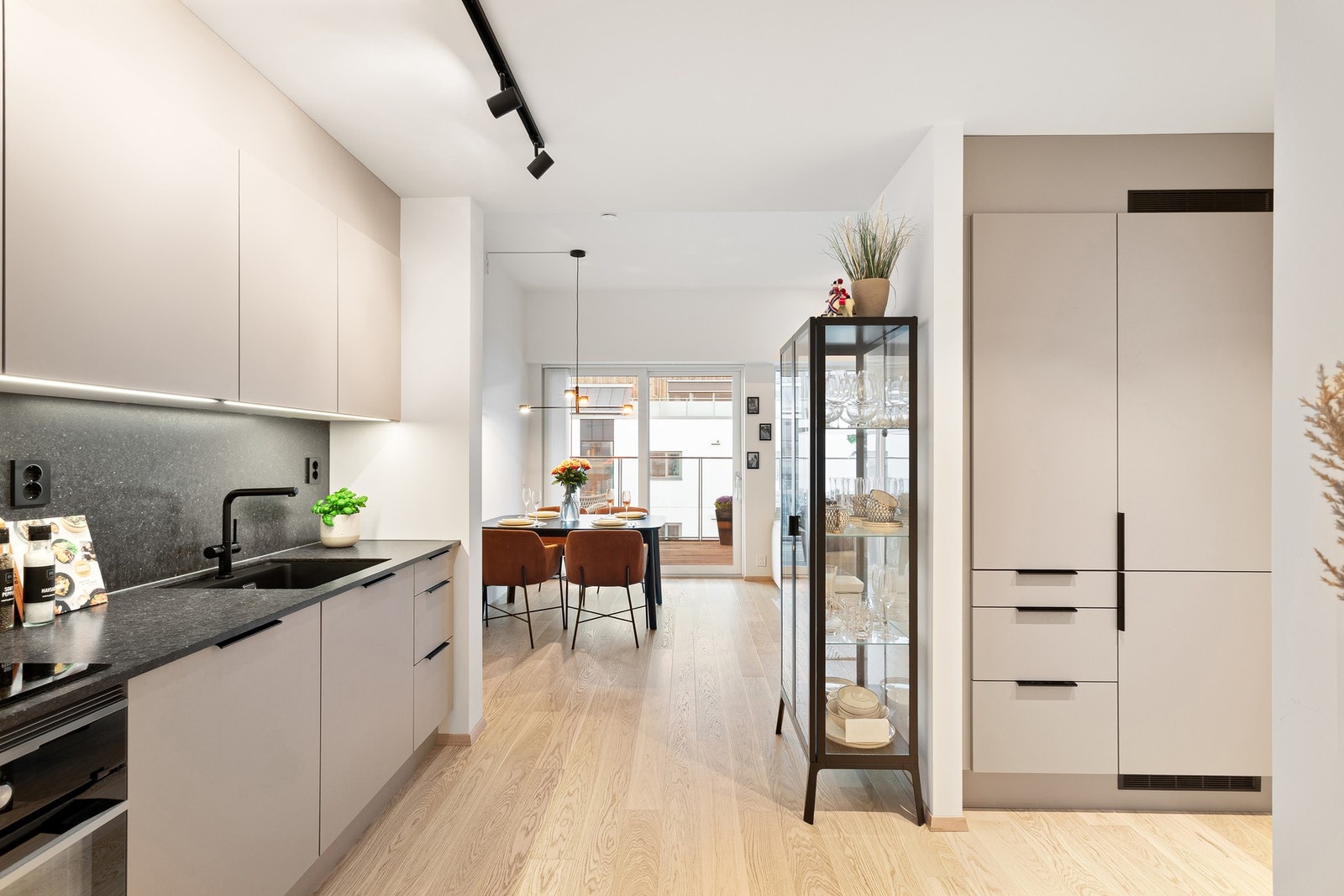 Leilighetens kjøkken ligger delvis adskilt fra stuen, er praktisk utformet og bidrar til optimal plassutnyttelse. I sideskapet til venstre for kjøl- fryseskapet er det installert dobbeltstikk. Praktisk for eksempelvis kaffemaskinen. Galleribilde