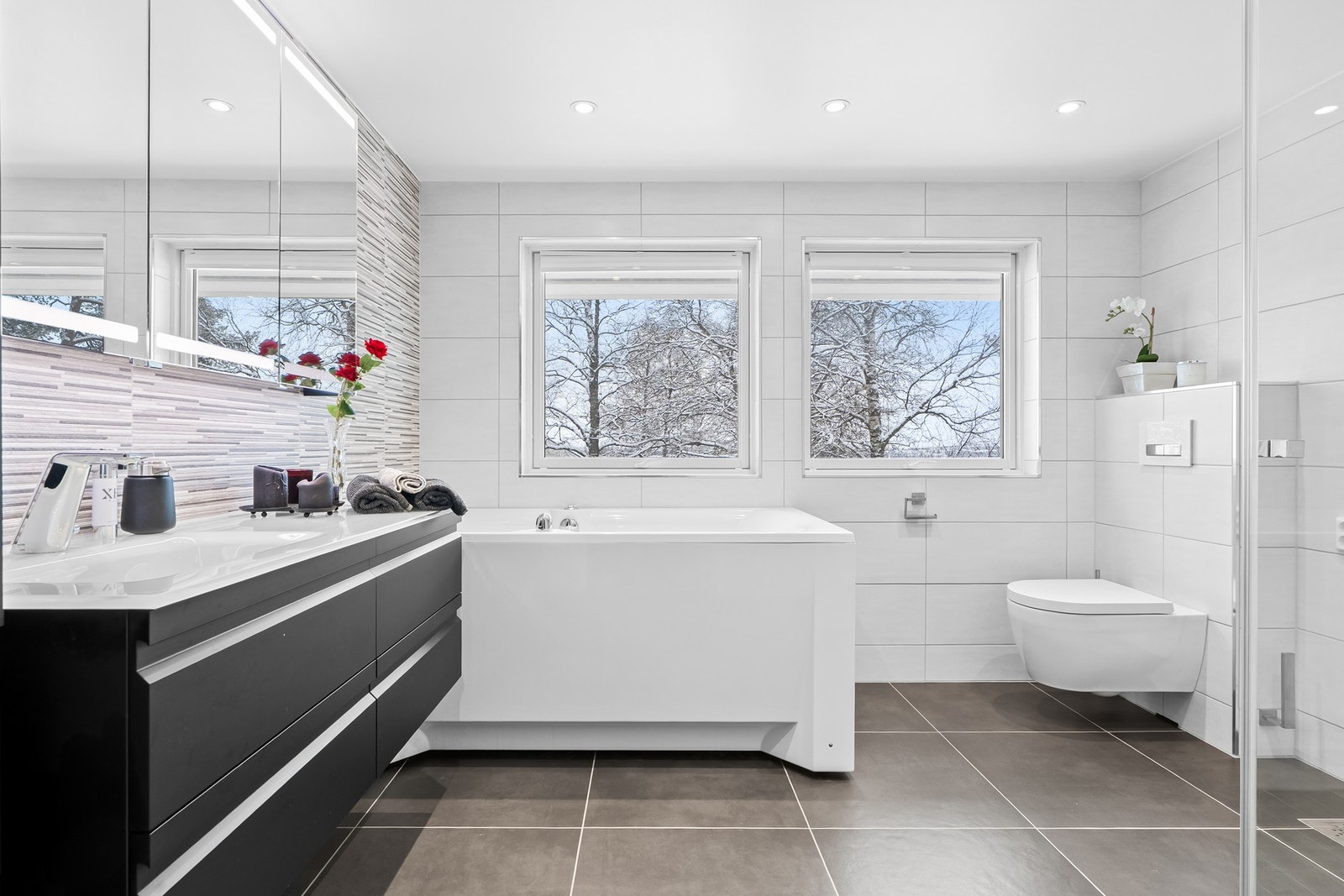 Romslig og moderne flislagt baderom. Galleribilde