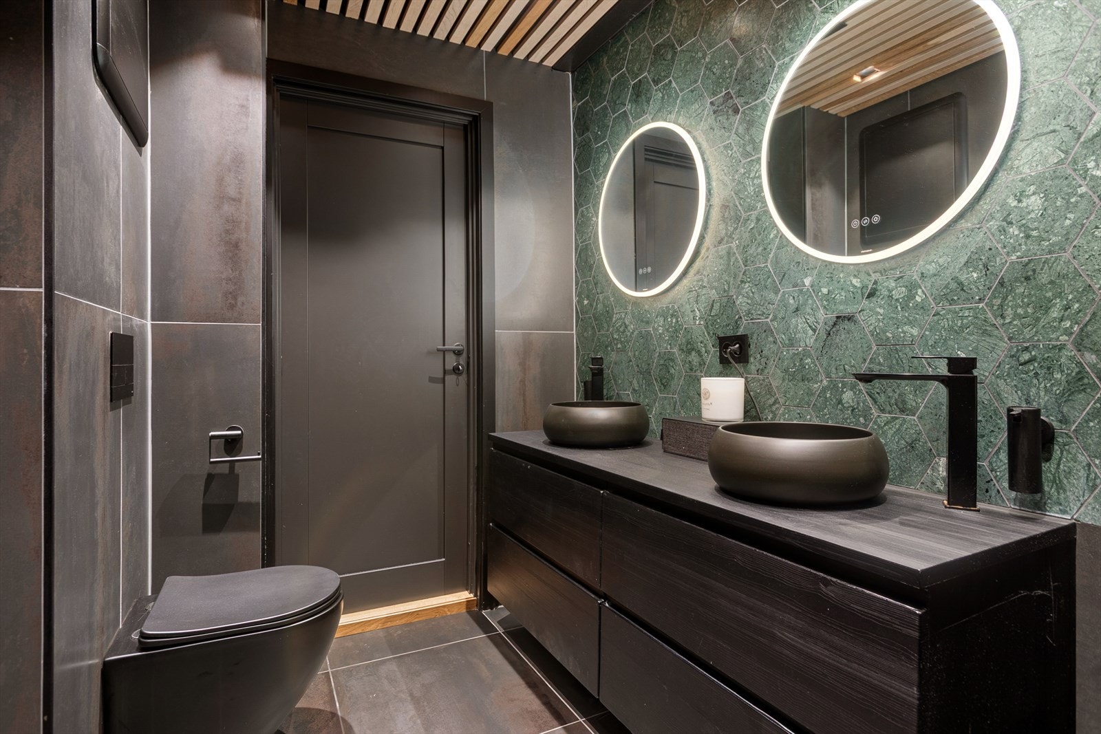 Badet har dobbel servant med skuffer, to speil med lys, vegghengt wc, regnfallsdusj og opplegg for vaskemaskin og tørketrommel. Galleribilde