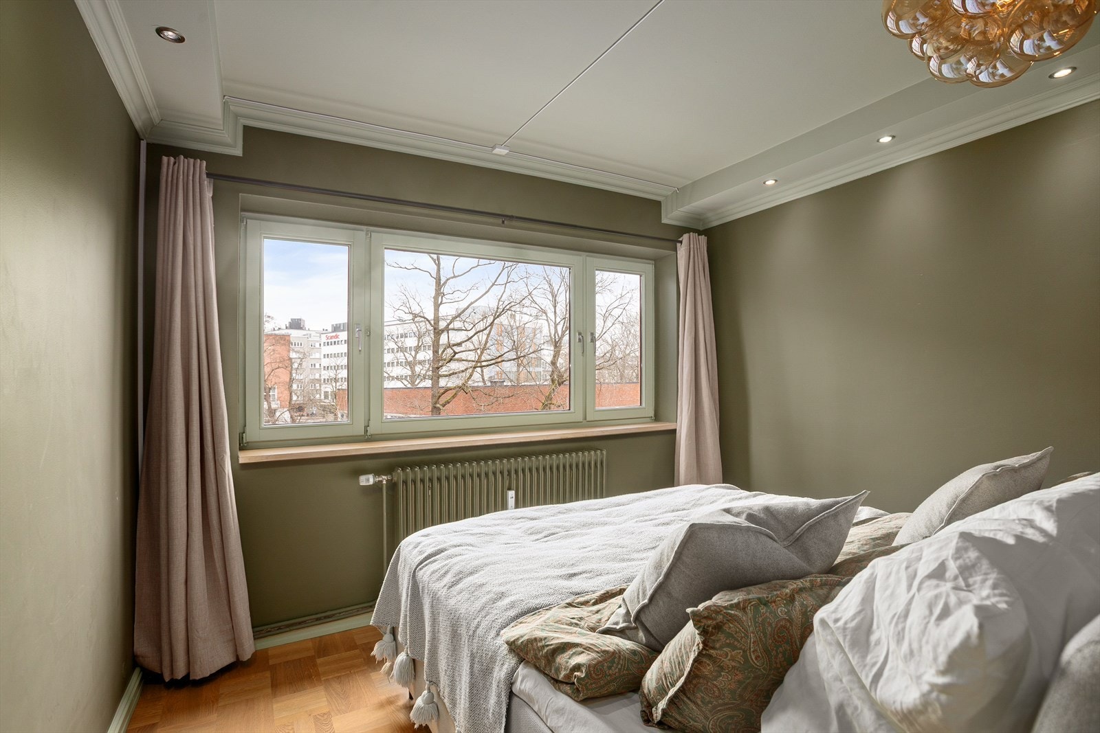 God plass til dobbeltseng, nattbord og tilhørende møblering. Hyggelig utsyn mot tretoppene på sommerstid. Galleribilde