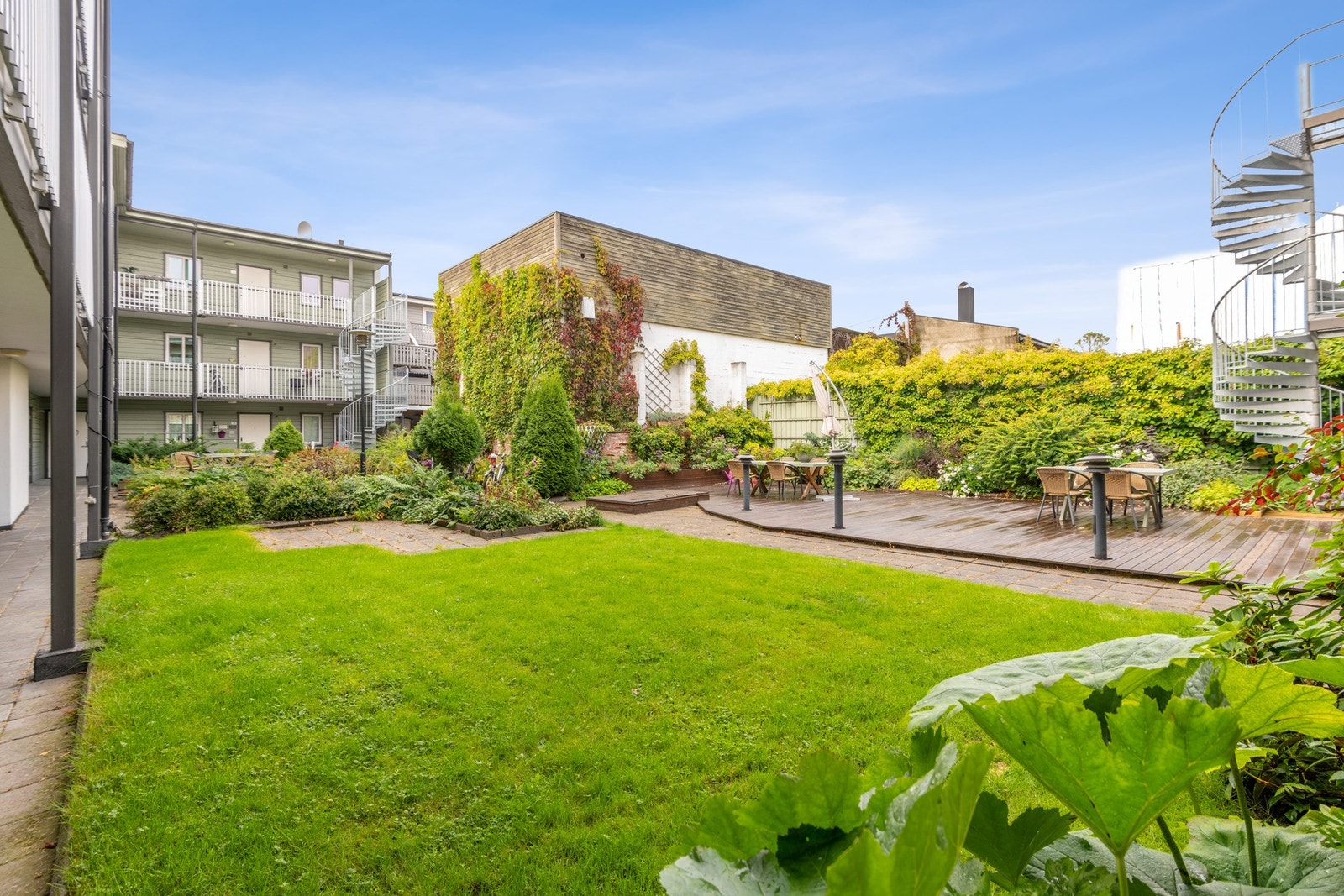 Fellesarealet er pent opparbeidet med markterrasser, plen og prydbusker. Galleribilde