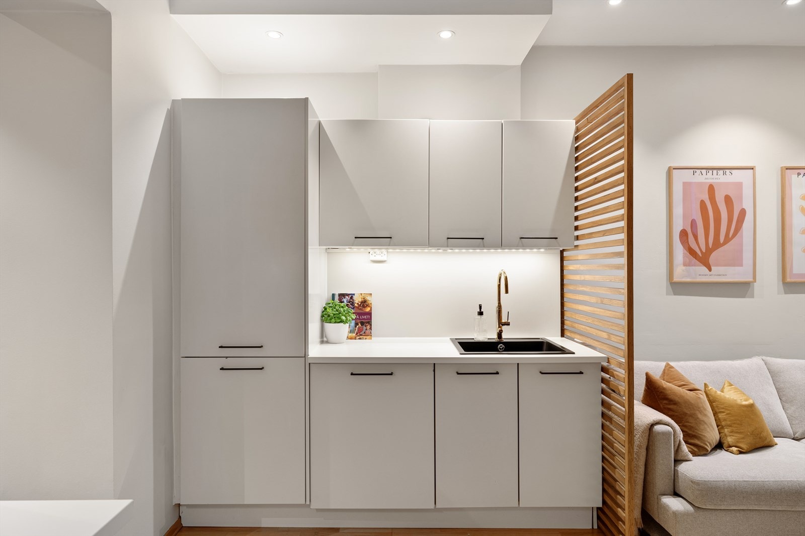 En elegant overgang mellom kjøkken og stue skaper naturlig soneinndeling i den åpne planløsningen. Galleribilde