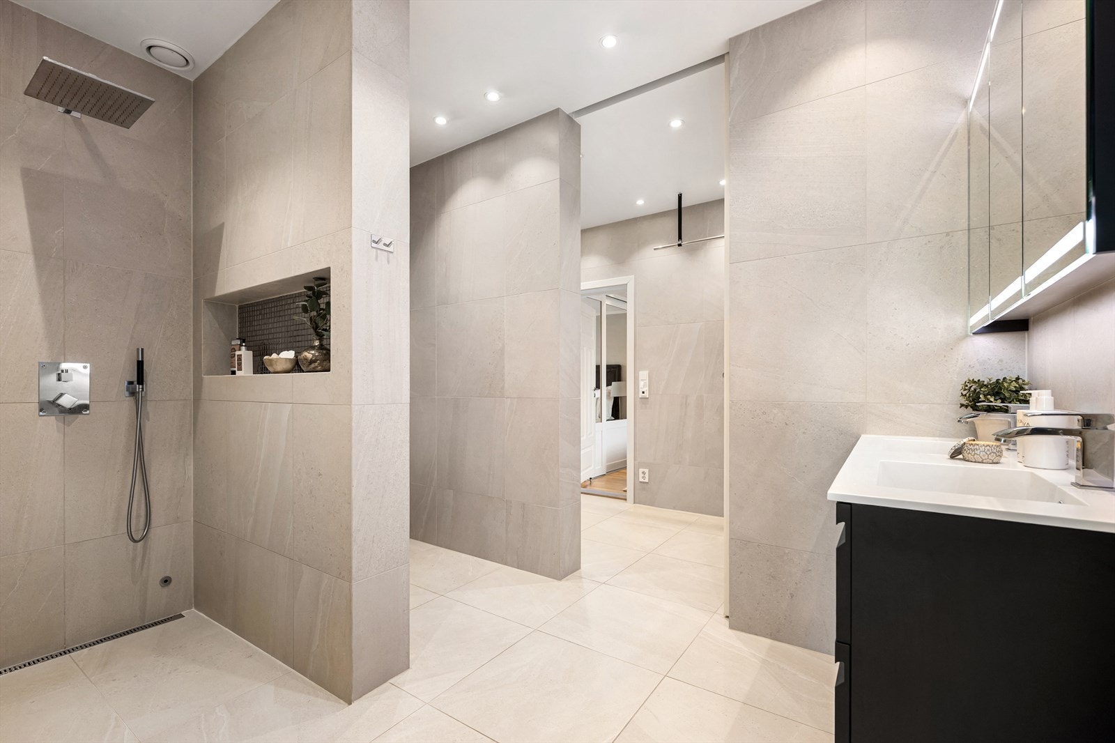 Badet er utstyrt med vegghengt wc, to servanter med innredning og regnfallsdusj med slukrenne Galleribilde