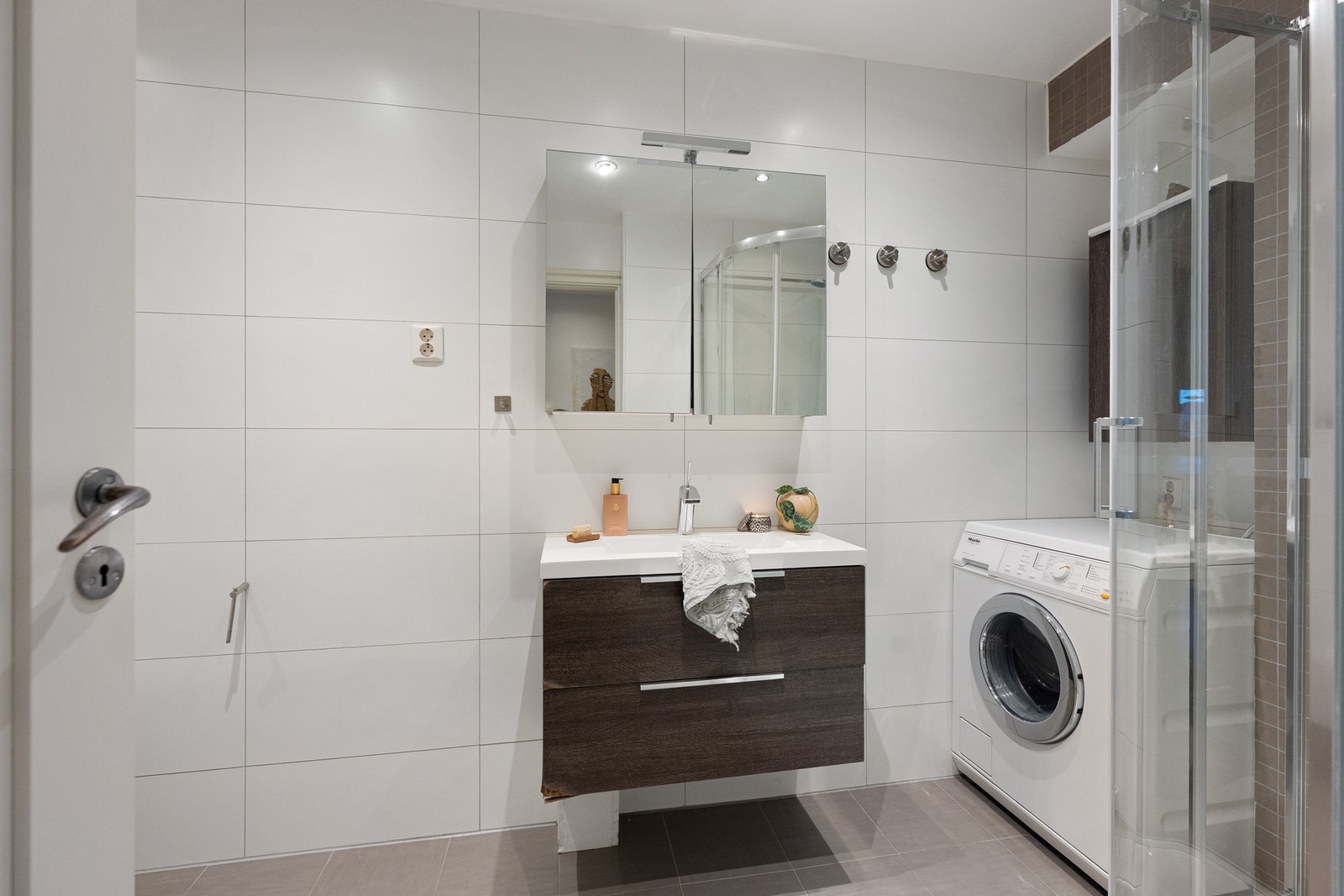 Flislagt bad med god plass til både vaskemaskin og oppbevaring. Galleribilde