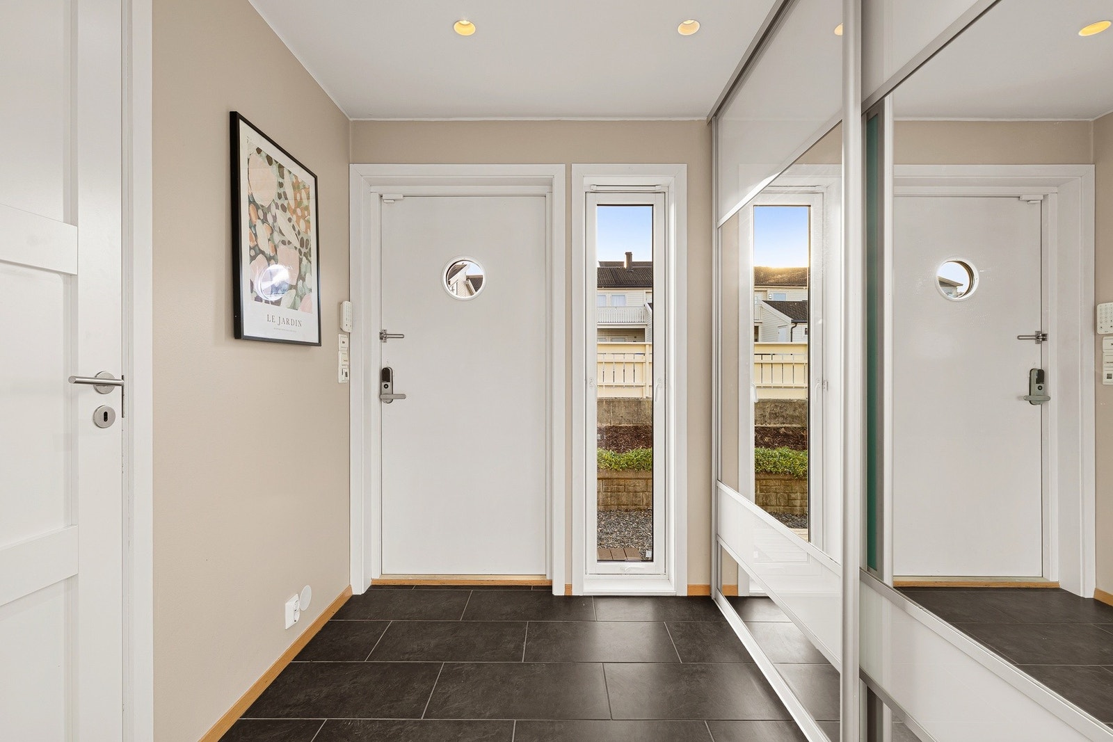 Velkommen inn | Pent inngangsparti med fliselagt gulv med varmekabler og innfelt downlights i taket | Stor speilskyvedørsgarderobe Galleribilde