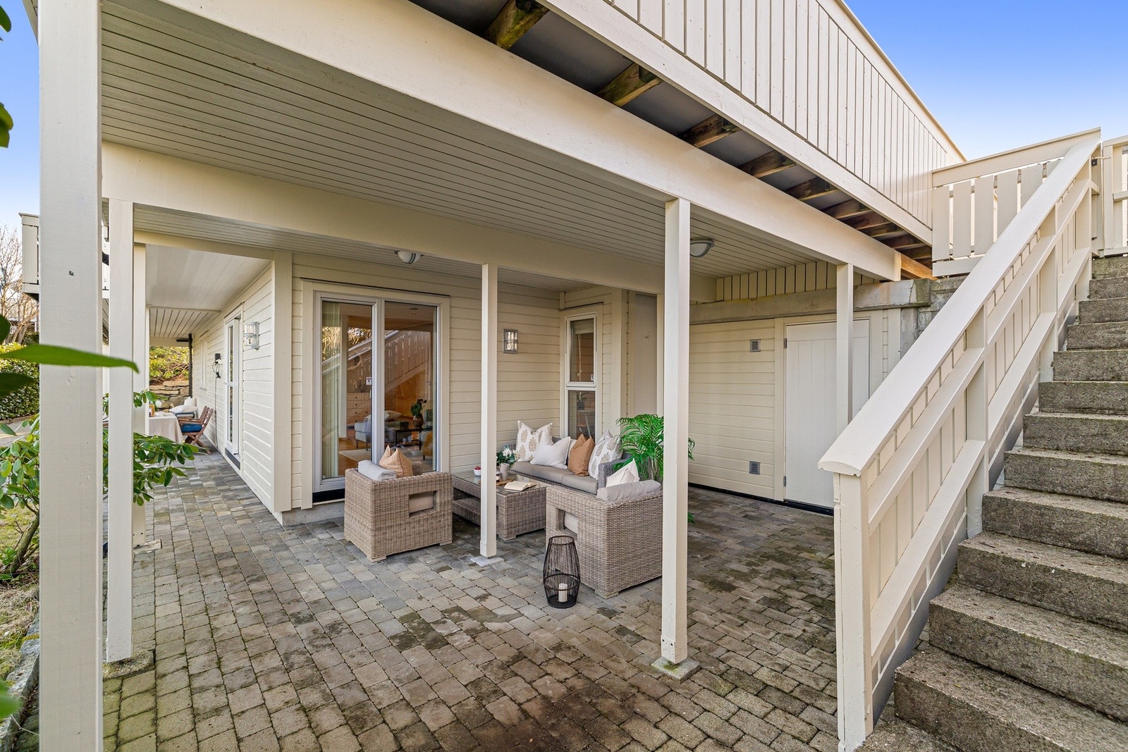 Fra begge kortsidene av huset er det trappetilkomst til terrassene og hagen på nedsiden av huset Galleribilde