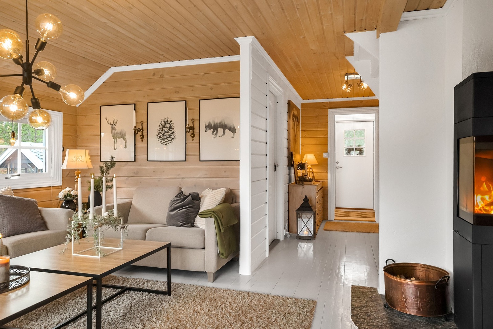 Stuen er av god størrelse og har beisede vegger og store vinduer Galleribilde