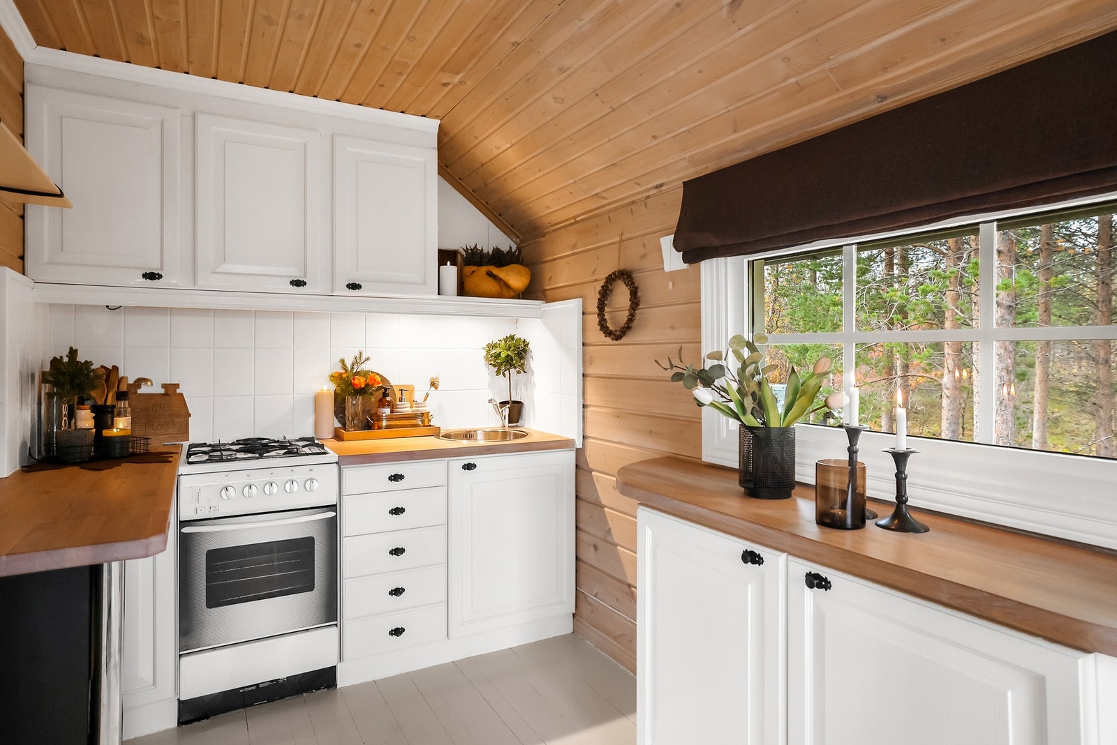 Kjøkkenet har innredning med malte fronter og benkeplate av heltre Galleribilde