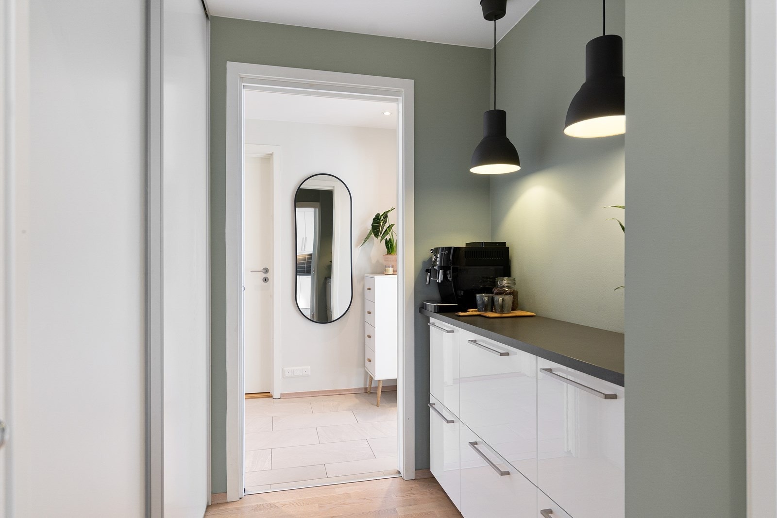 Praktisk mellomgang med benkeplass og oppbevaring i skyvedørsgarderobe. Her er det perfekt tilrettelagt for et eget kaffehjørne. Galleribilde