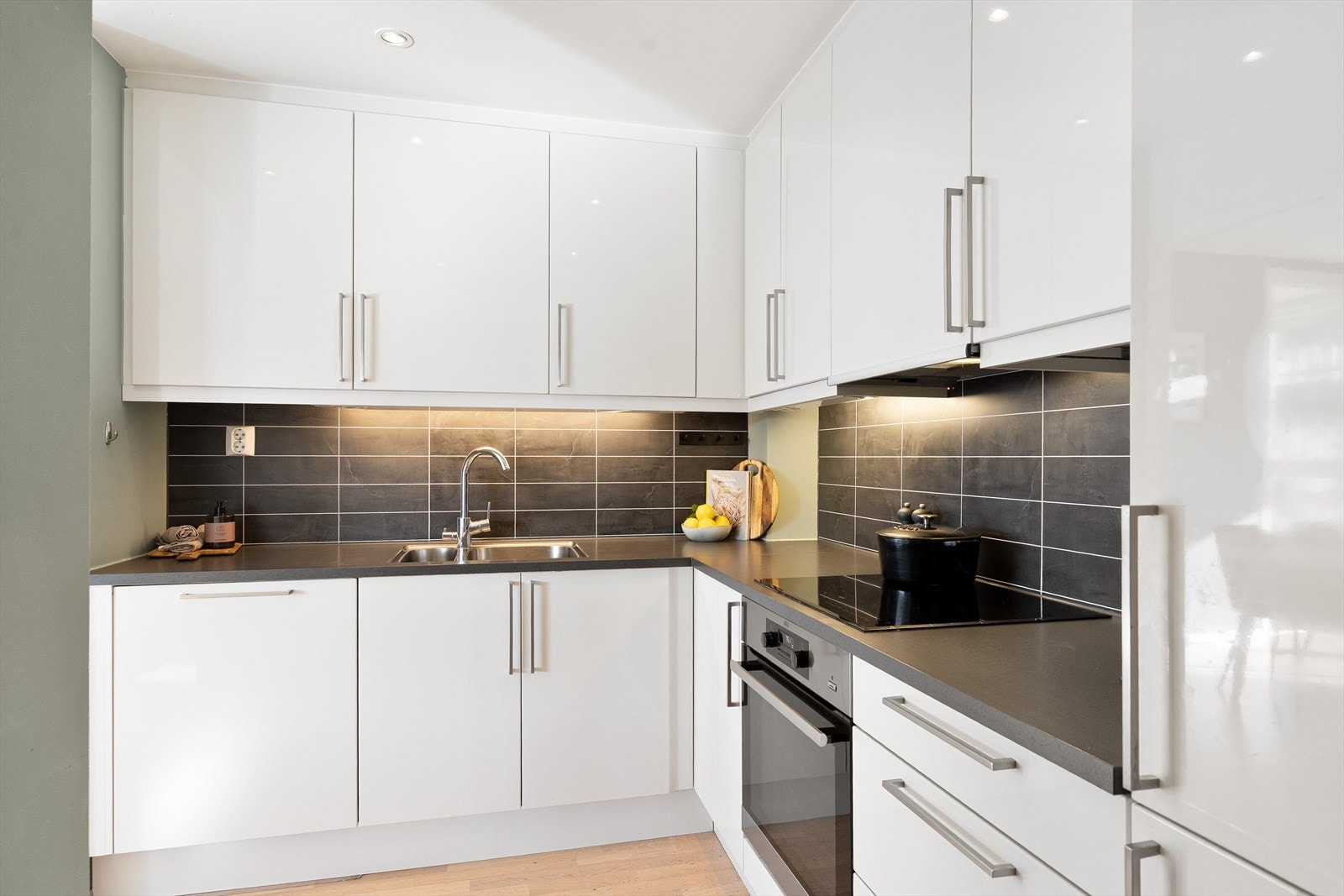 Kjøkkenet er utstyrt med integrerte hvitevarer, herunder induksjonstopp, stekeovn, kjøleskap og fryseskap. Galleribilde