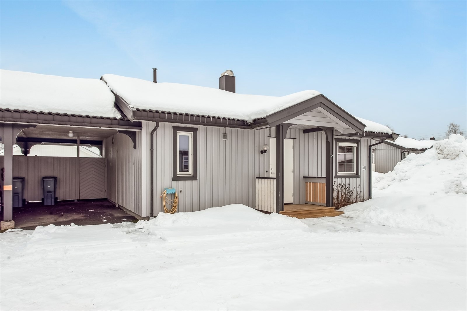 Eiendommen har en tilhørende carport med en bod på 17 m² for ekstra lagring. Galleribilde