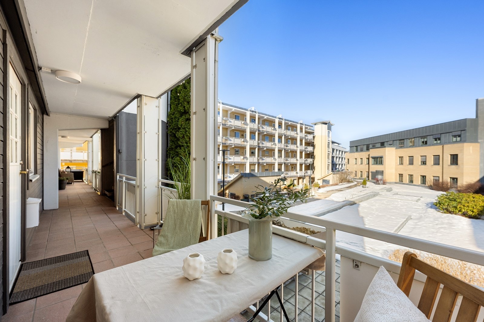 Hyggelig uteplass ved inngangsdør, med plass til bord og stoler. Fint utsyn mot tunet/fellesareal Galleribilde