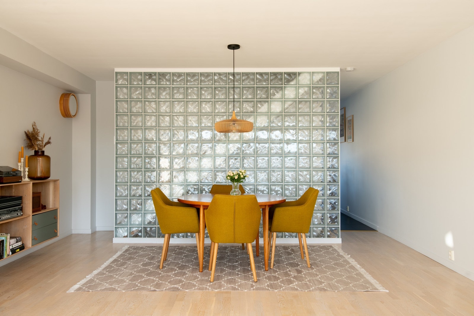 En vegg med glassbyggerstein deler stuen i soner på en elegant måte. Galleribilde