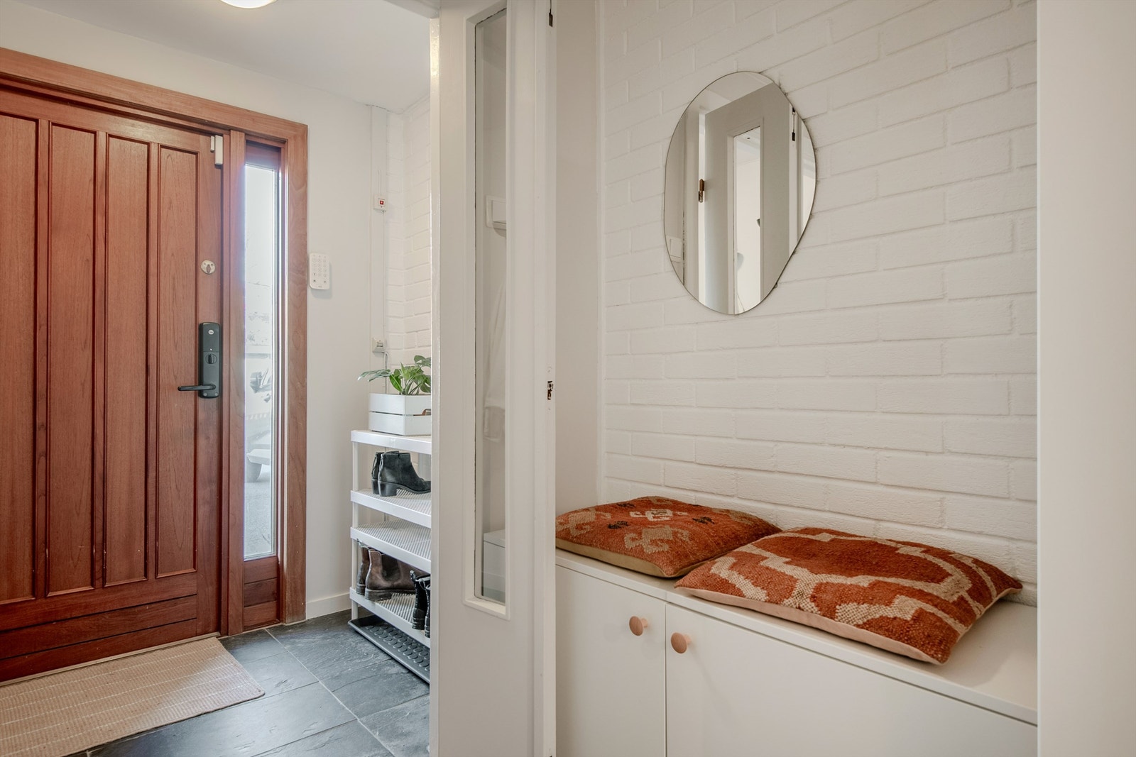 Innbydende entré med flislagt gulv, gulvvarme og detaljer i teglstein. Galleribilde