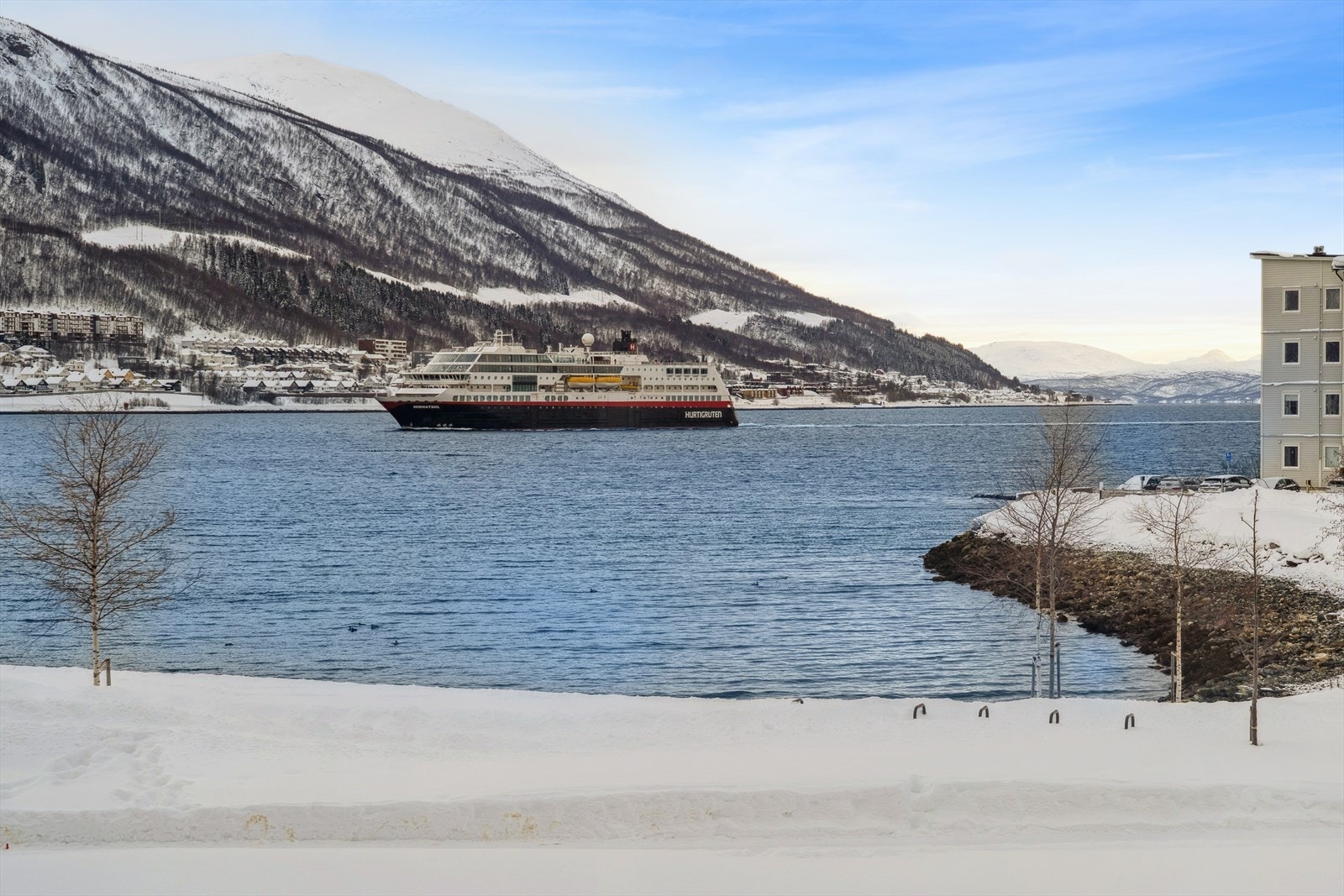 Utsikt mot den vakre innseilingen til Tromsø, hvor båtlivet og det skiftende fjordlandskapet skaper et stemningsfullt skue året gjennom. Galleribilde