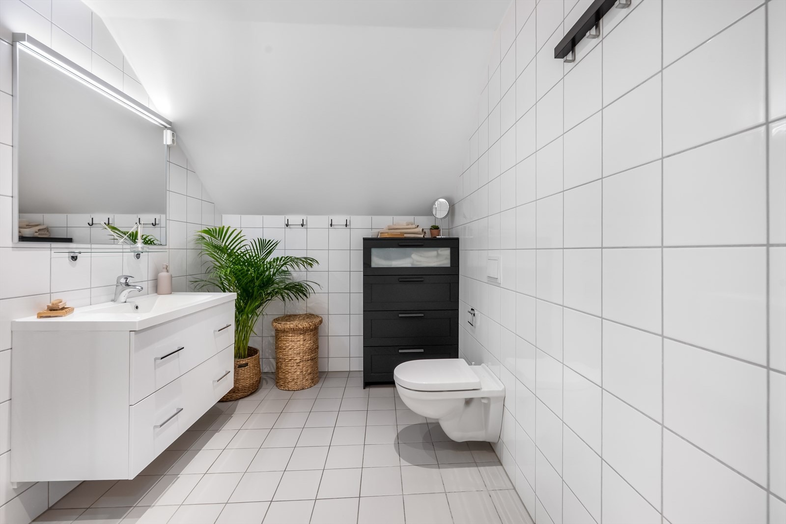 Her er det veggmontert toalett, servantinnredning og elektriske varmekabler i gulvet. Galleribilde