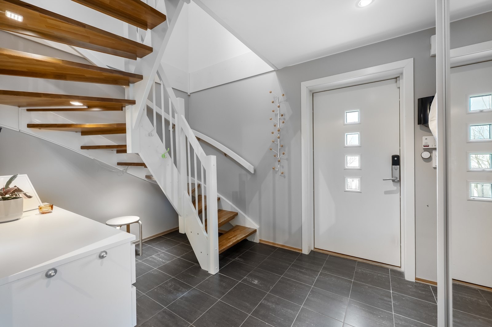 Velkommen inn i en lys entré med flislagt gulv m/varmekabler og plass til oppbevaring. Galleribilde