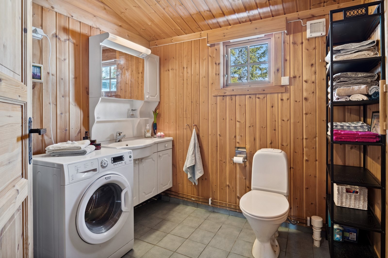 Baderom med flislagt gulv med varmekabler, panel på vegger, opplegg for vaskemaskin, god skapplass i baderomsinnredning. Badstue med adkomst fra baderom Galleribilde