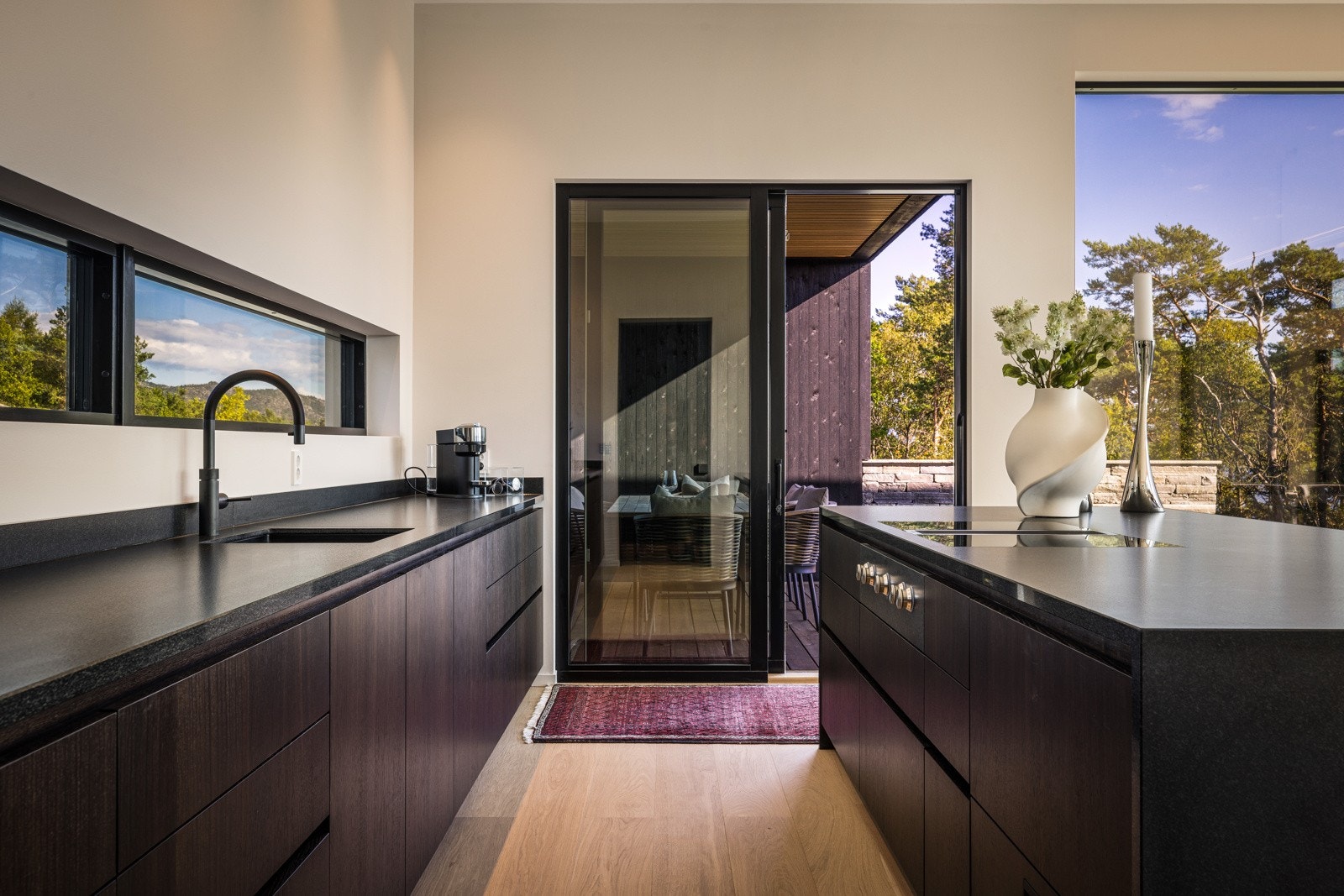 - Kjøkkenets benkeplate er av matt, sort granitt med underlimt vask og armatur fra Dornbracht, med coocker som gir både varmt, kaldt og kullsyre vann - Galleribilde