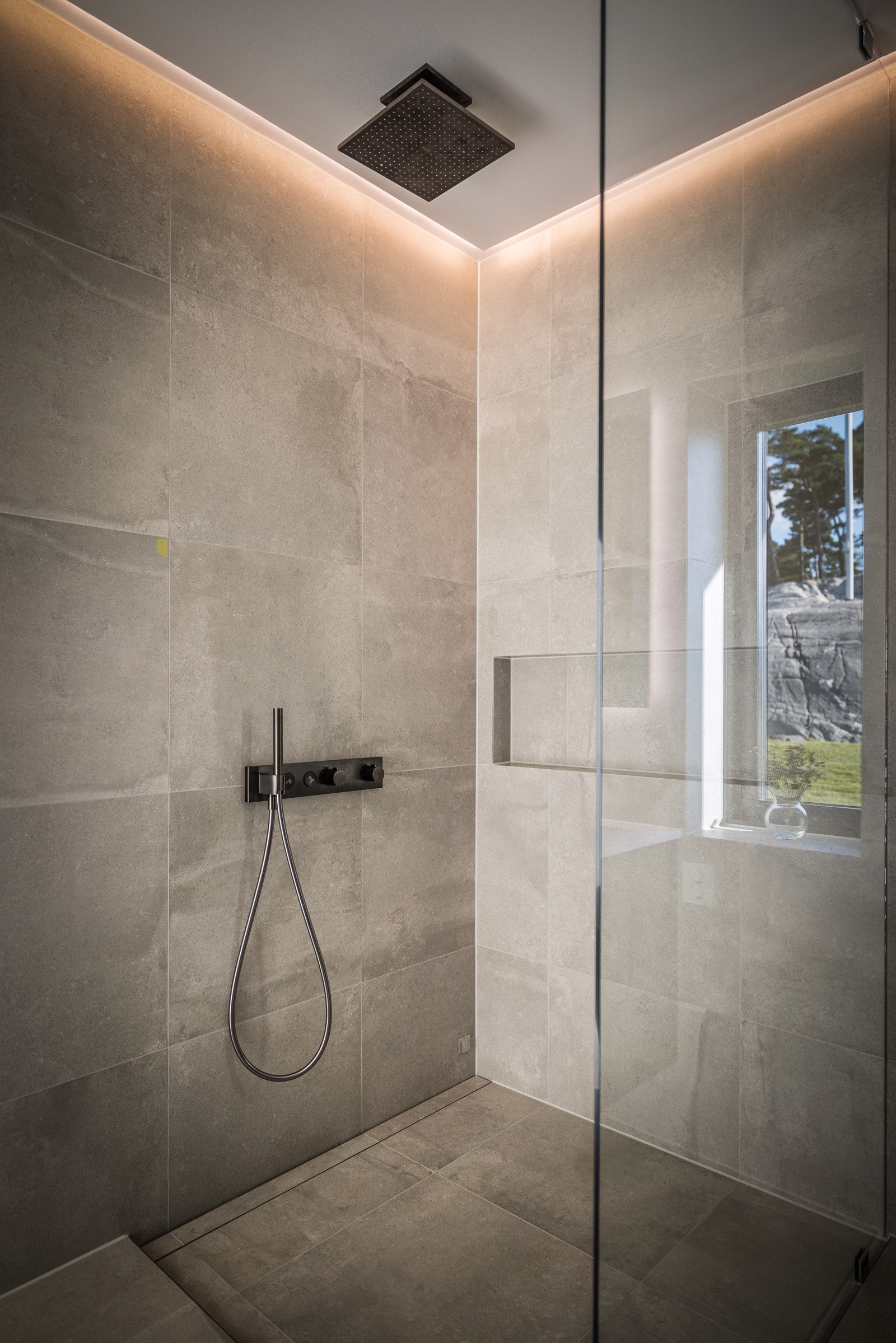 - Badet har en romslig og komfortabel dusj med glassvegg med en lekker og funksjonell innfelt hylle og regndusj fra Axor Citterio - Galleribilde