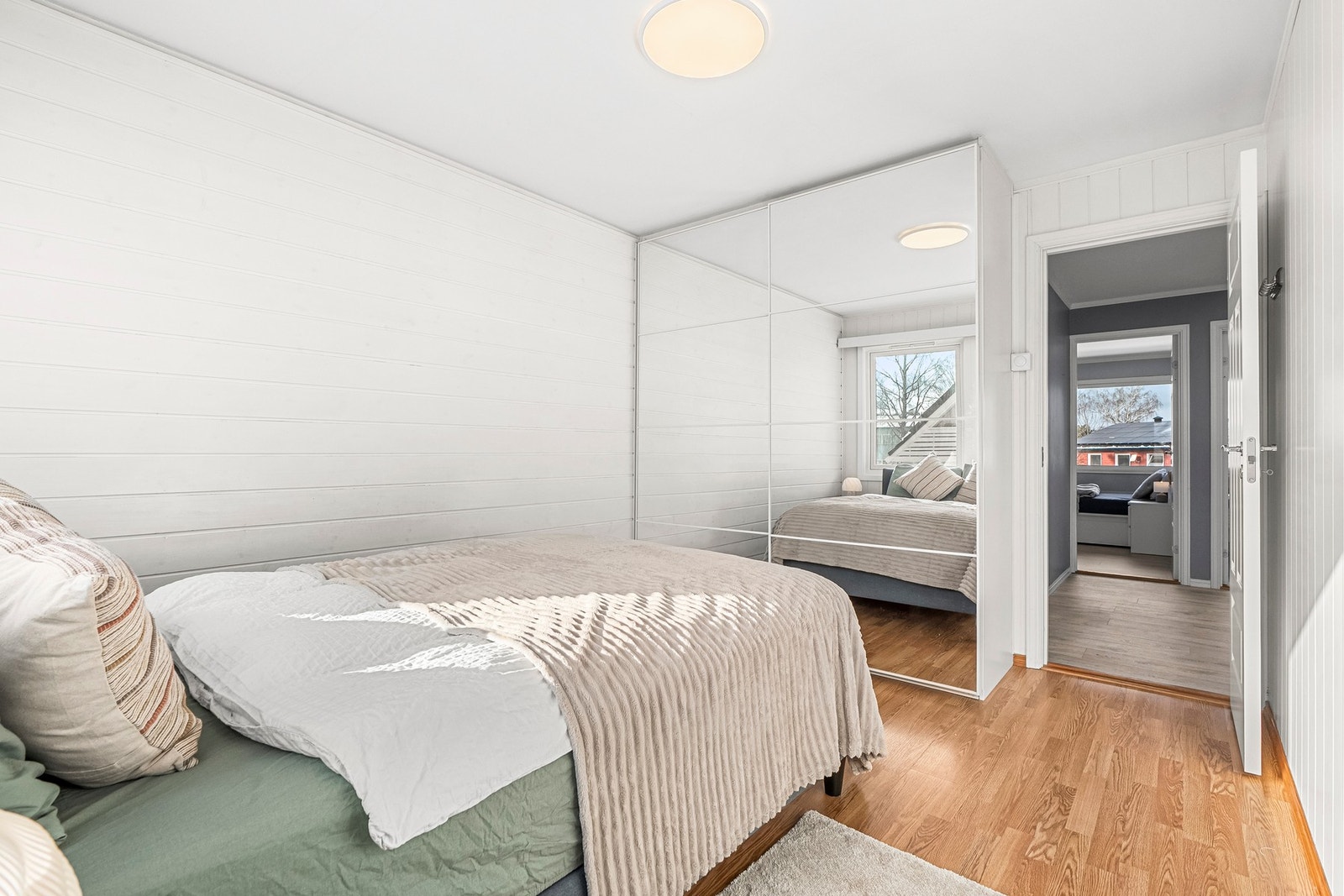 Rommet har et stort garderobeskap med skyvedører i speil. Galleribilde