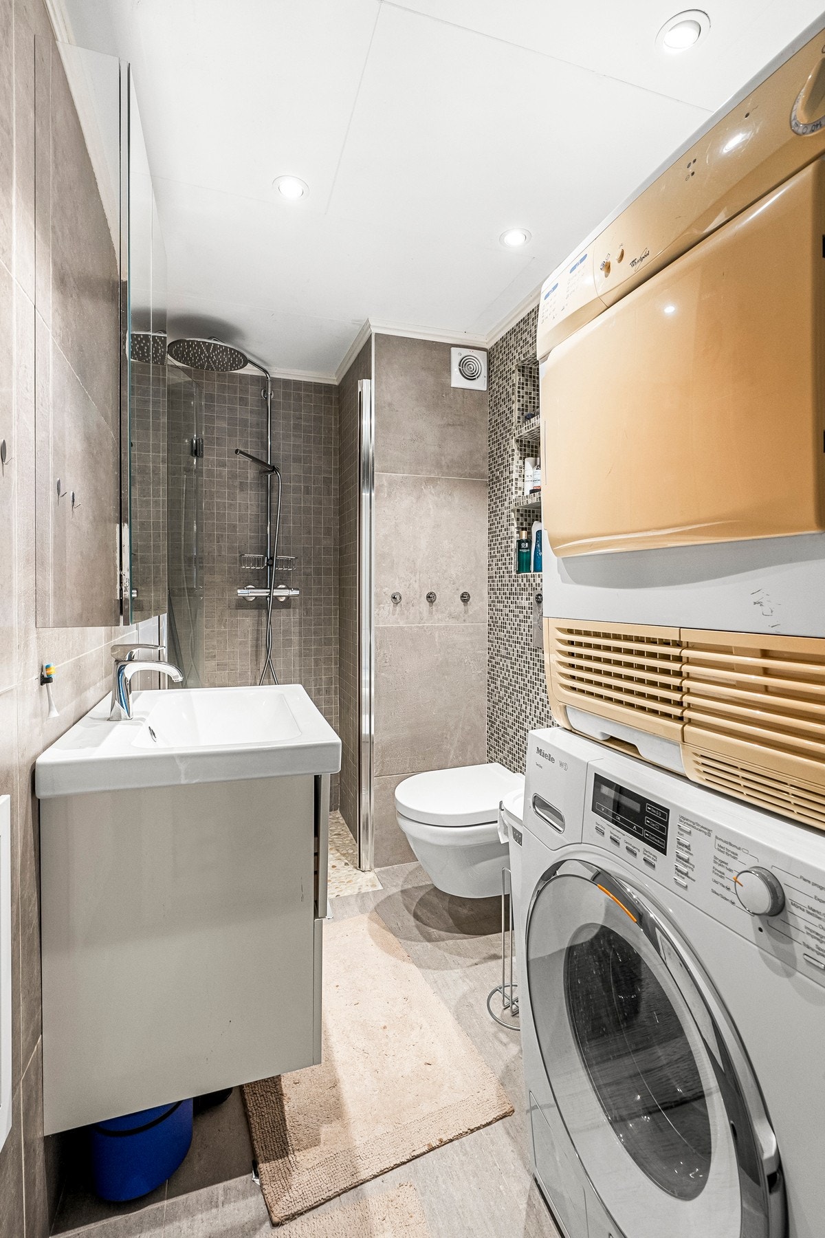 Pent flislagt bad/wc fra 2018 med takdusj, servantinnredning, vegghengt toalett, varmekabler og opplegg for vaskemaskin. Galleribilde