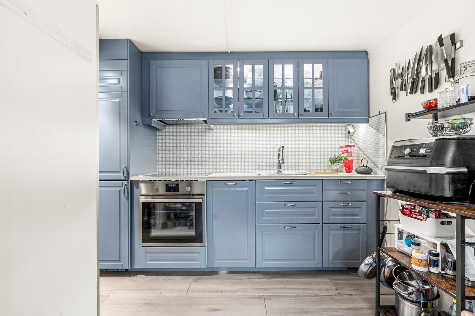 Kjøkkeninnredning fra IKEA (2018) i delikat blå tone med integrerte hvitevarer og god skapplass. Galleribilde