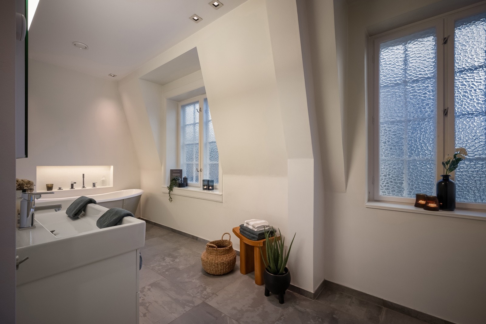 Takhøyden er flott og den luftige følelsen understrekes av to vinduer med bred karm og ruglete glass. I tillegg har leiligheten et praktisk vaskerom, vegg-i-vegg med baderommet. Galleribilde